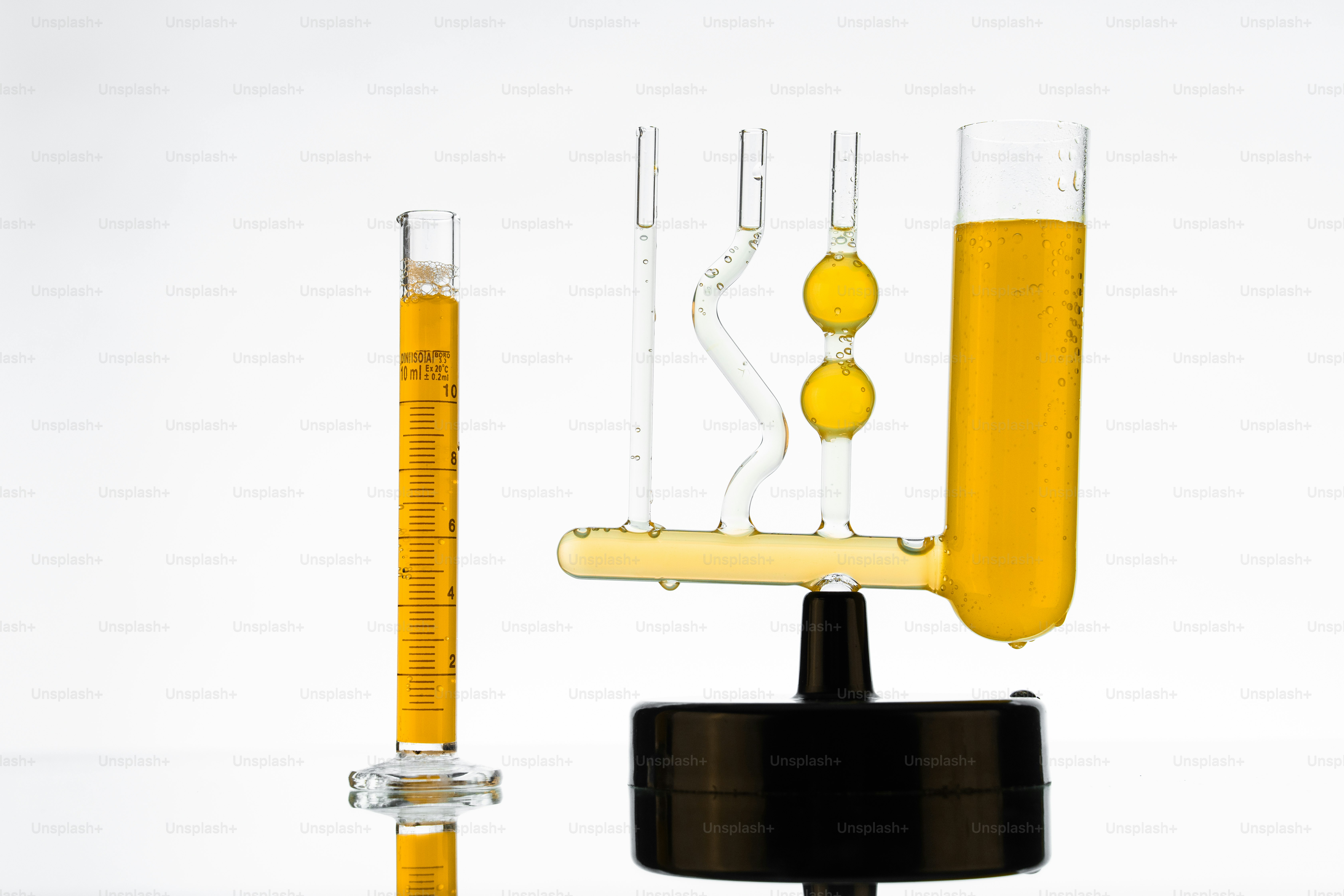 Hydrometer with yellow liquid on white background