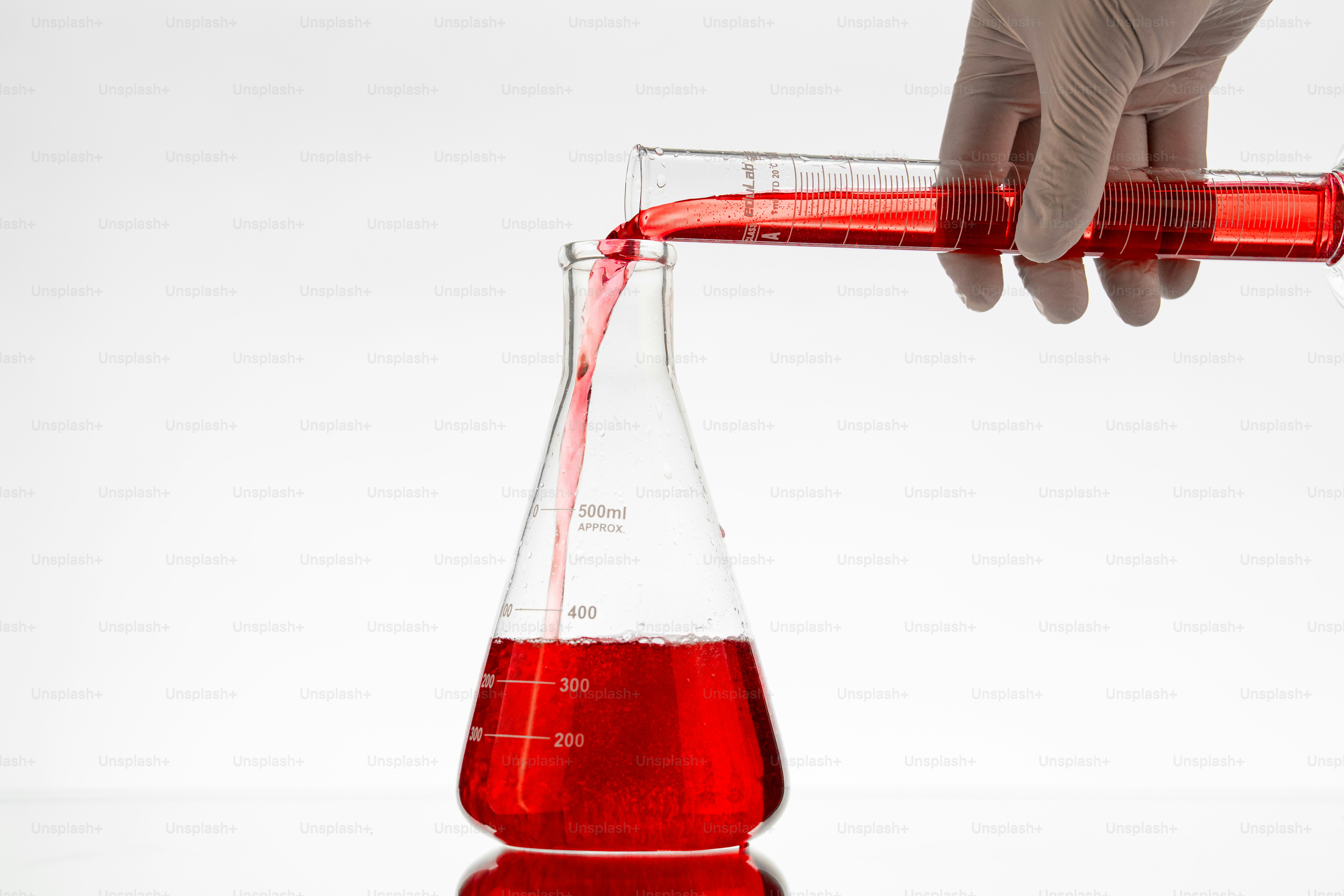 Red liquid poured into an erlenmeyer flask