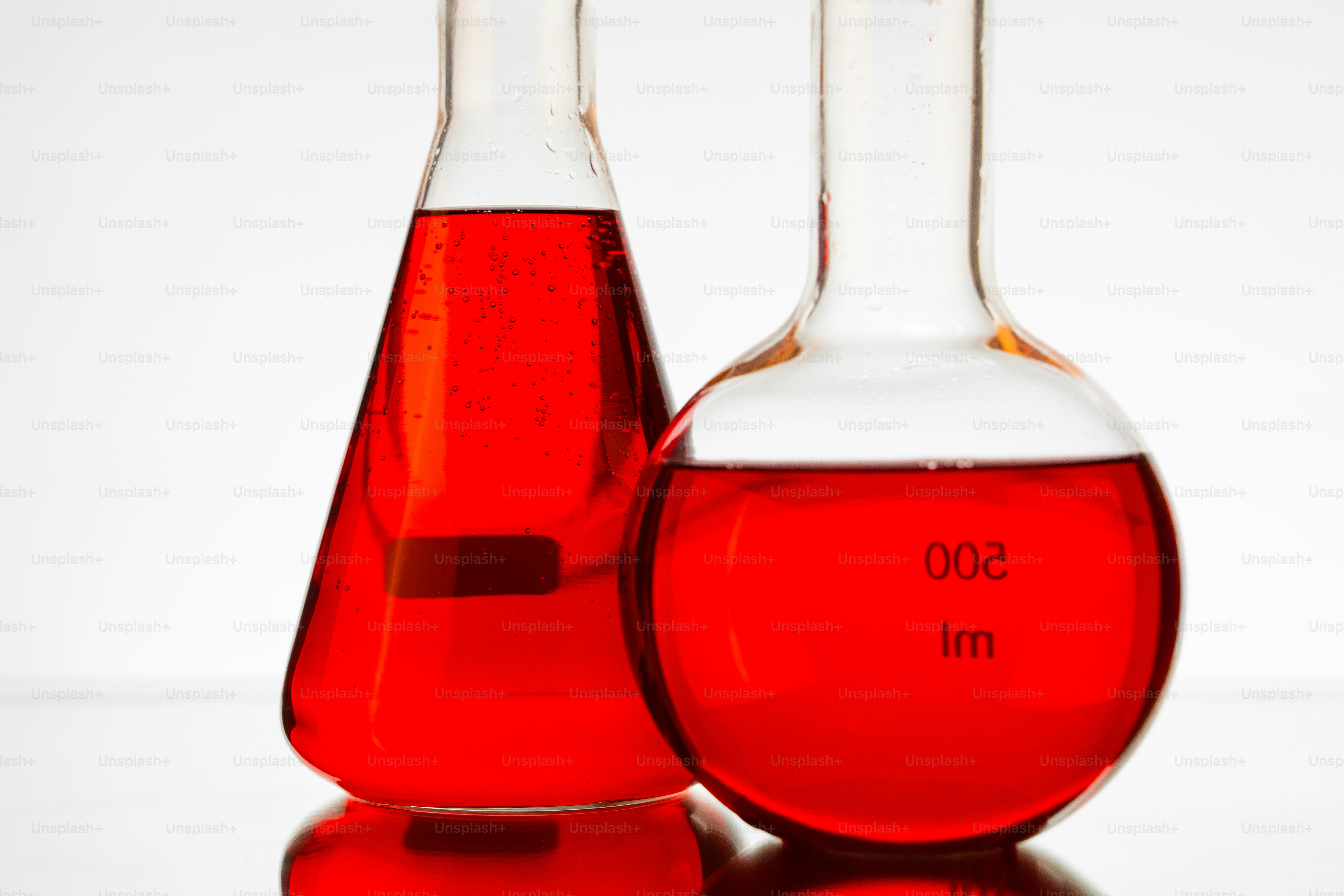 Two laboratory flasks with red liquid