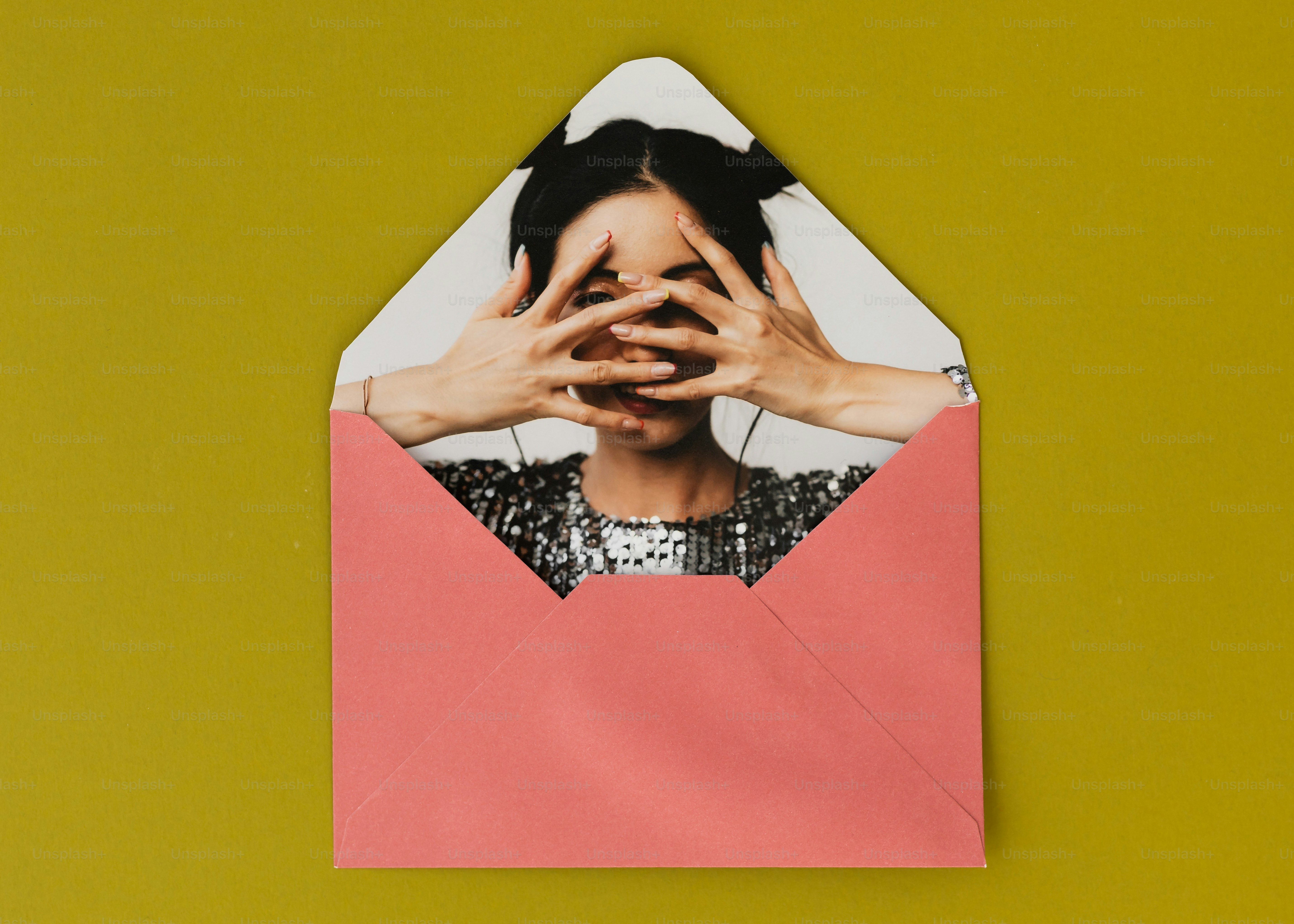 Woman peeking from pink envelope on yellow background