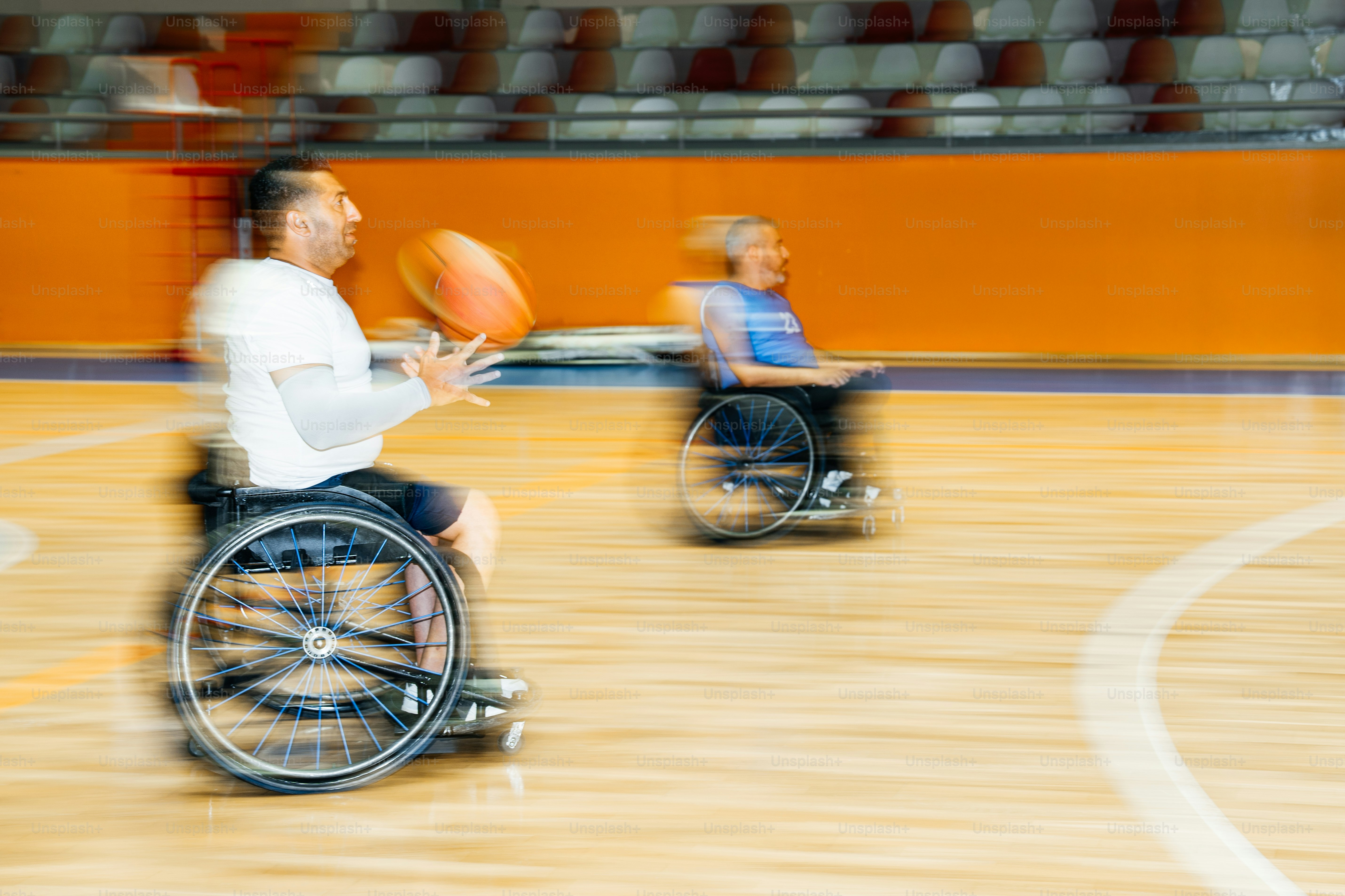 Zwei Personen spielen Rollstuhlbasketball auf einem Platz.