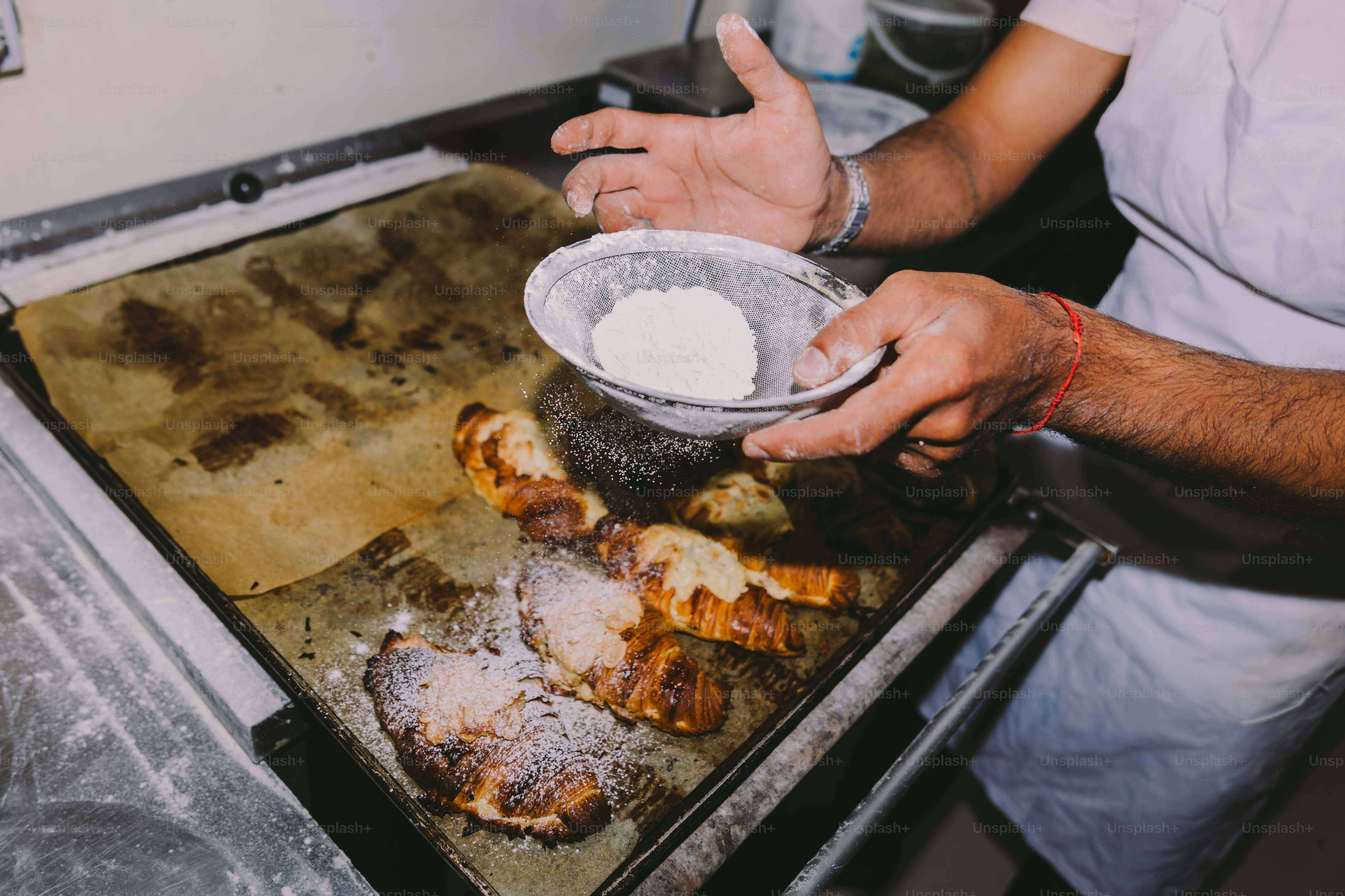 Baker dusting croissants with powdered sugar photo – Bakery Image on ...