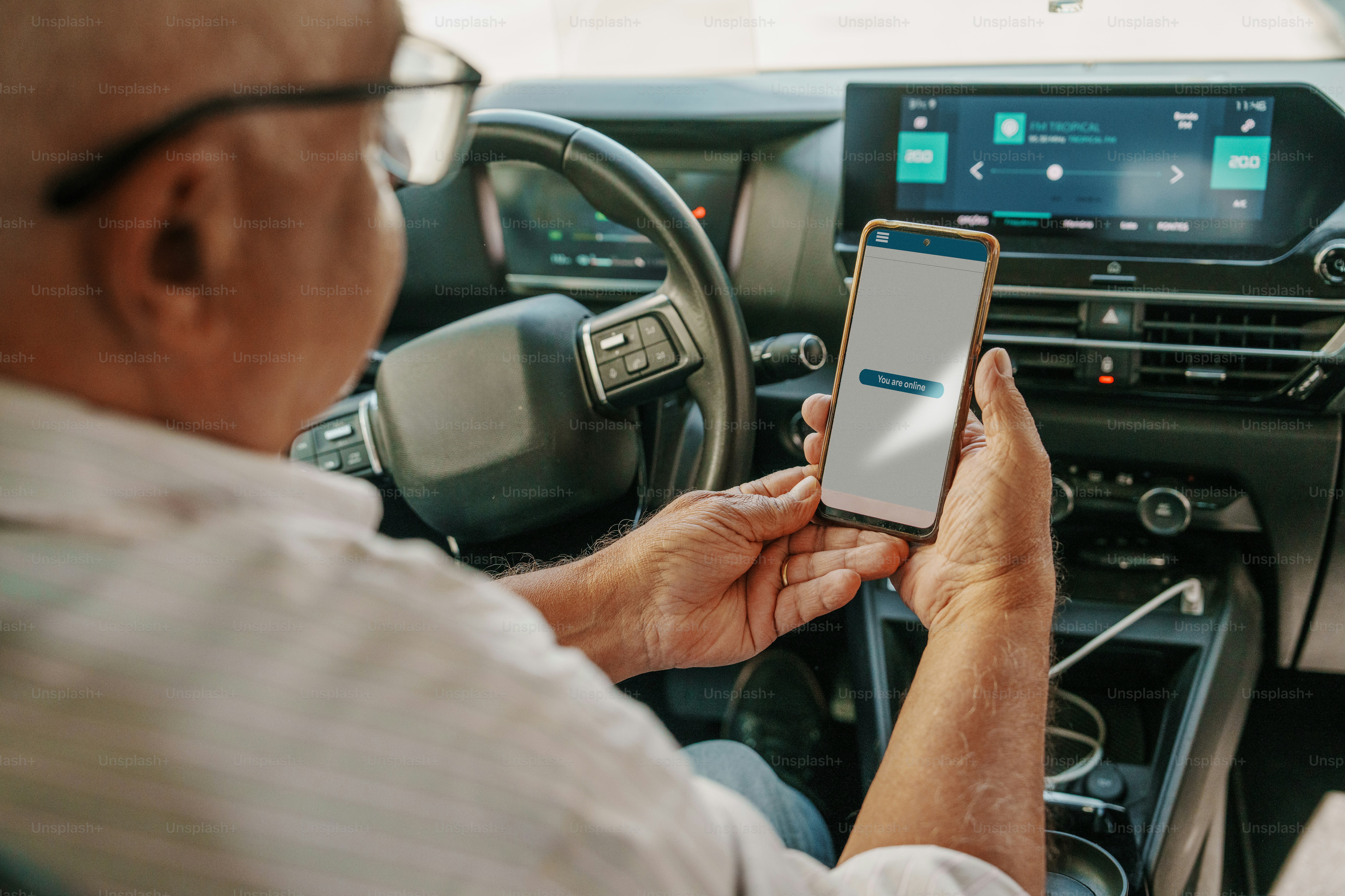 Hombre usando un teléfono inteligente en el tablero del automóvil