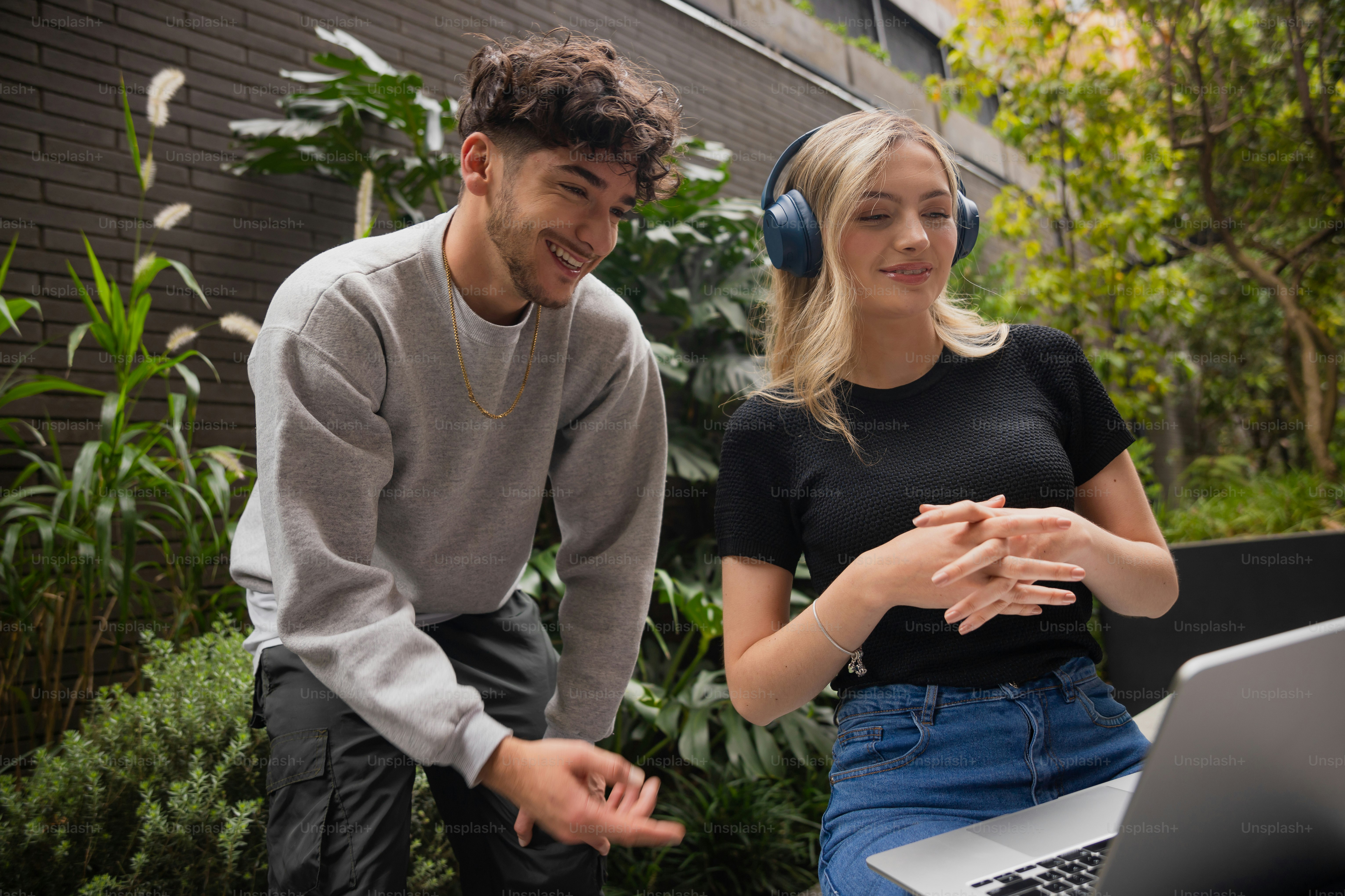 Pareja joven mirando computadora portátil al aire libre