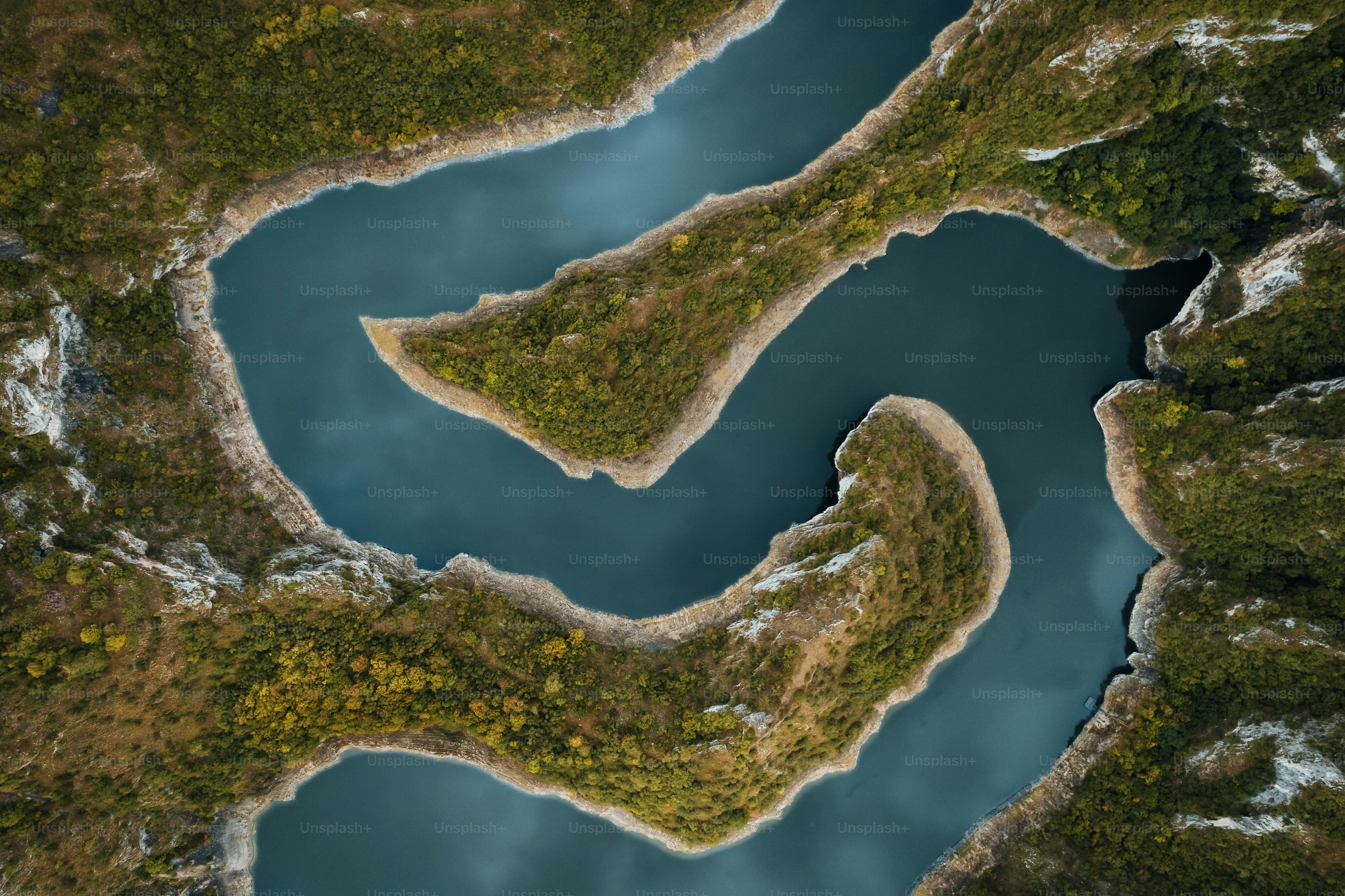 Aerial view of a winding river through green hills