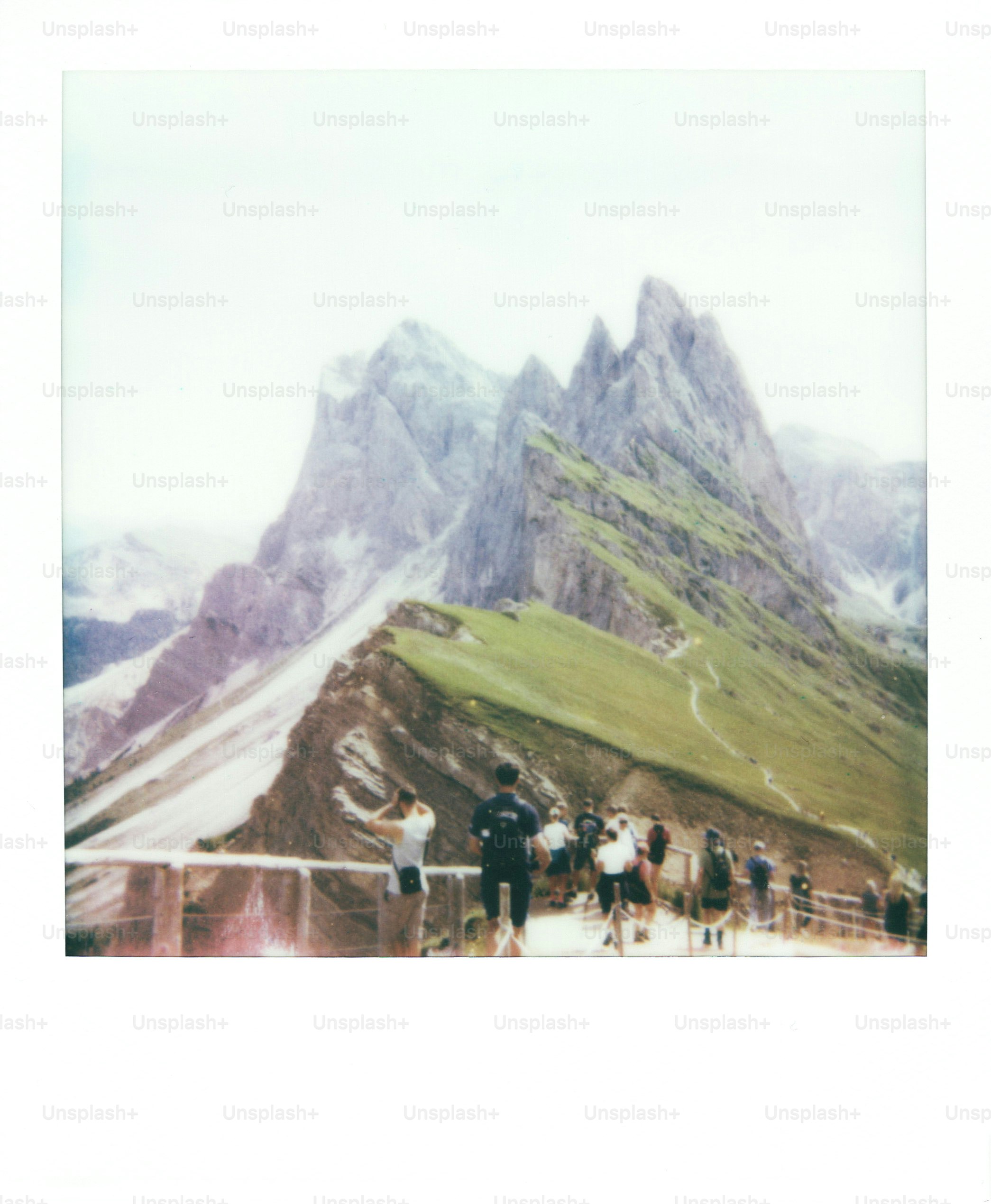 People on a scenic mountain ridge with jagged peaks.