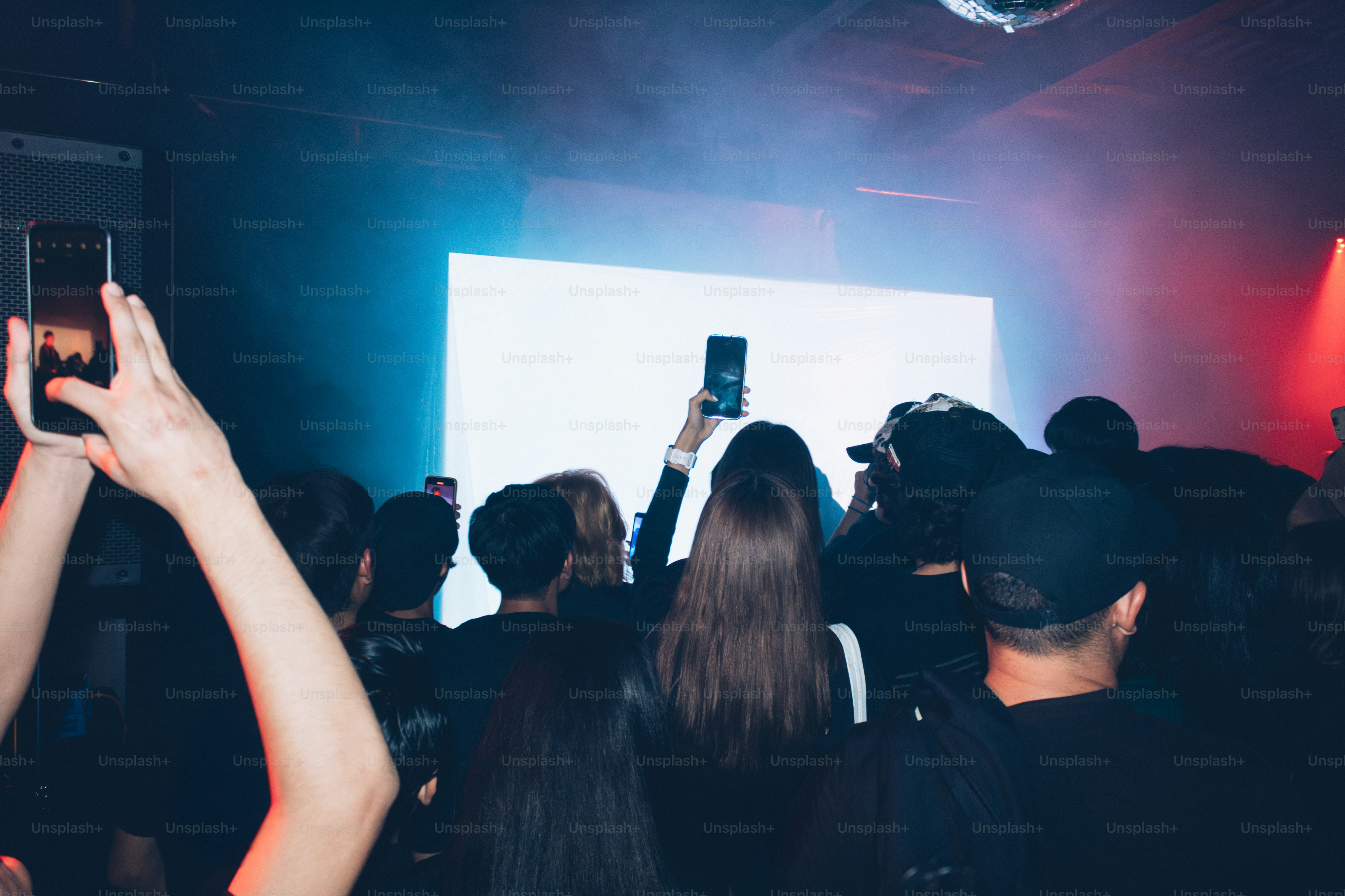 Crowd watching a performance with hands raised.