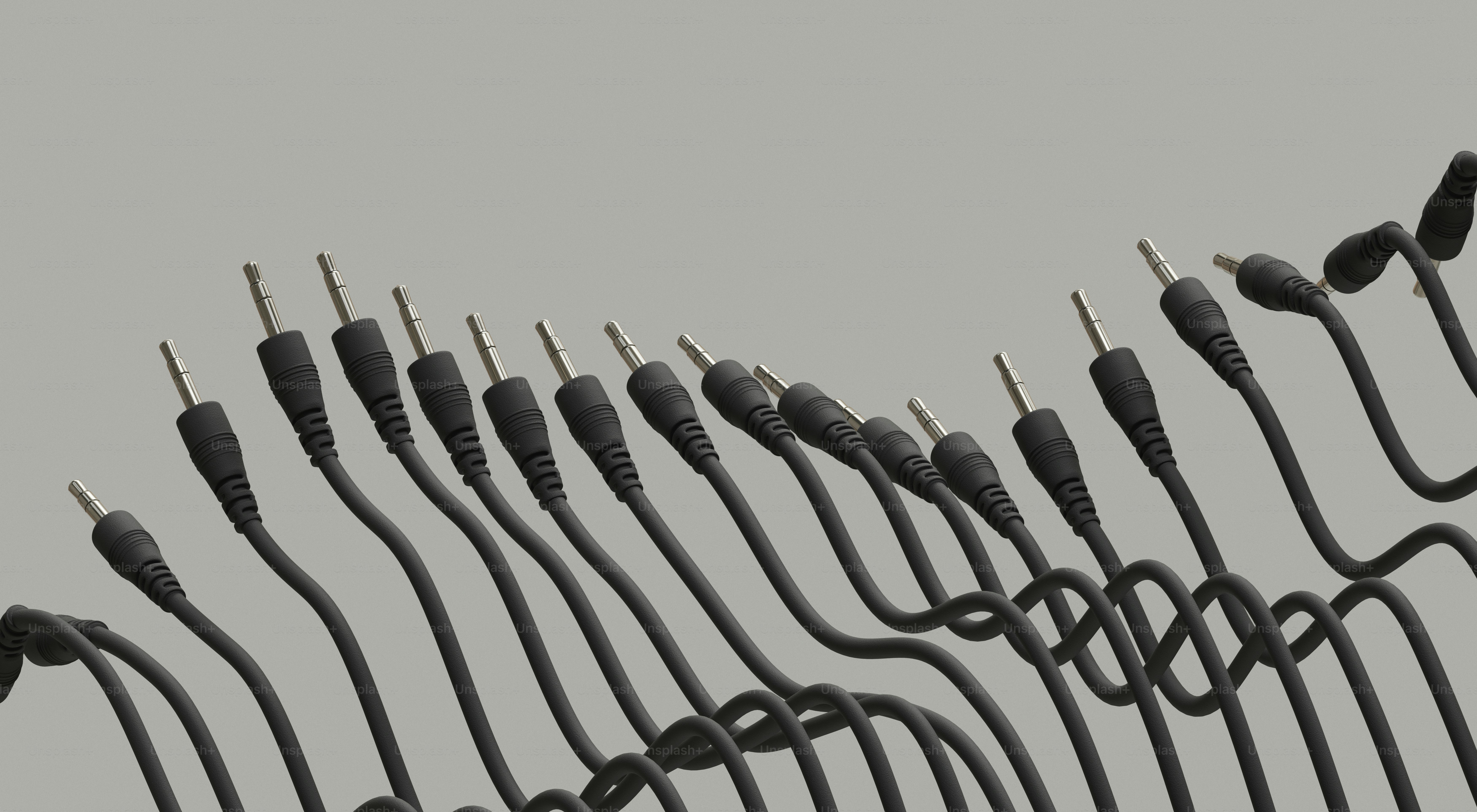 Vários cabos de áudio pretos dispostos em um padrão de onda