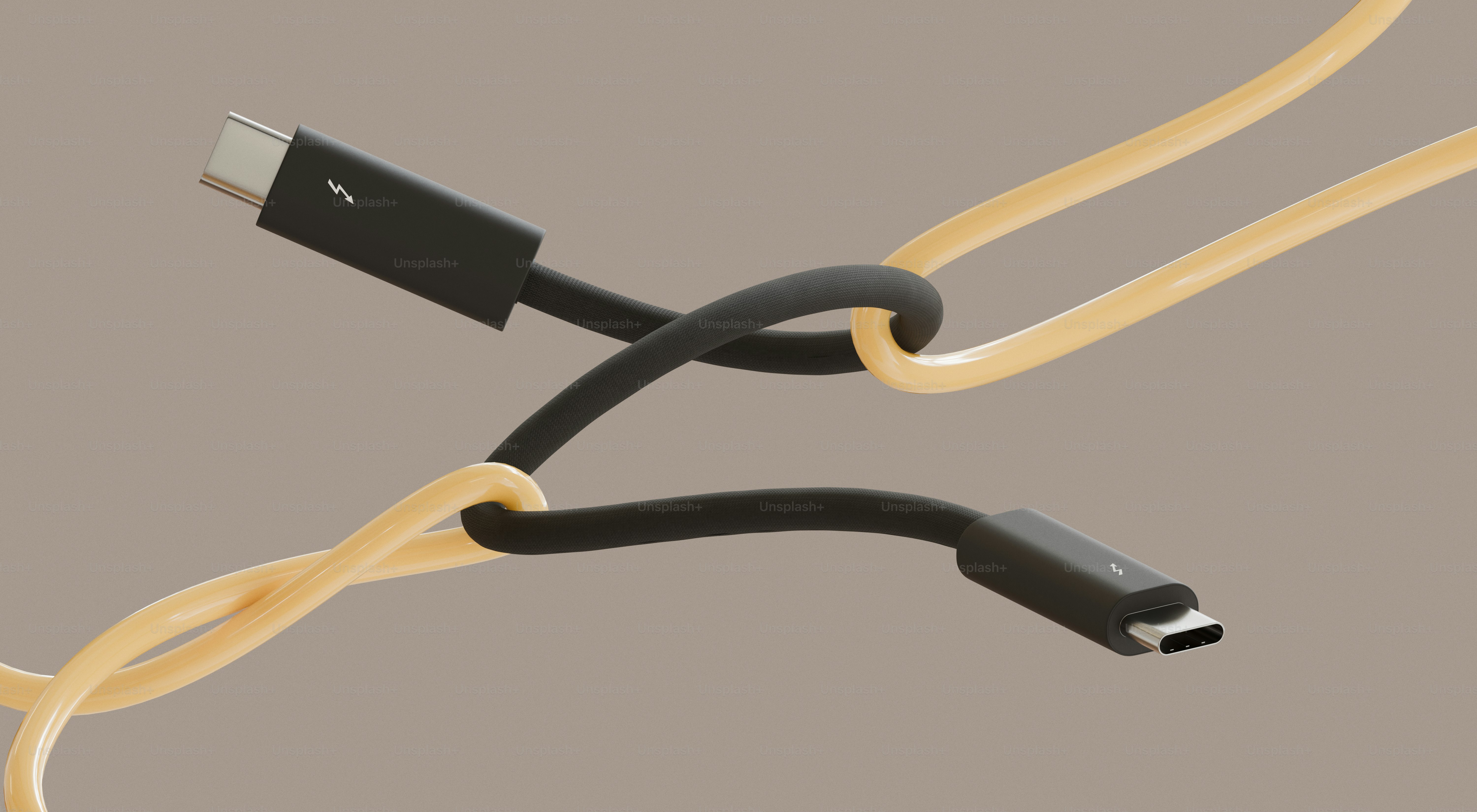 Dois cabos USB-C amarrados juntos em um fundo liso