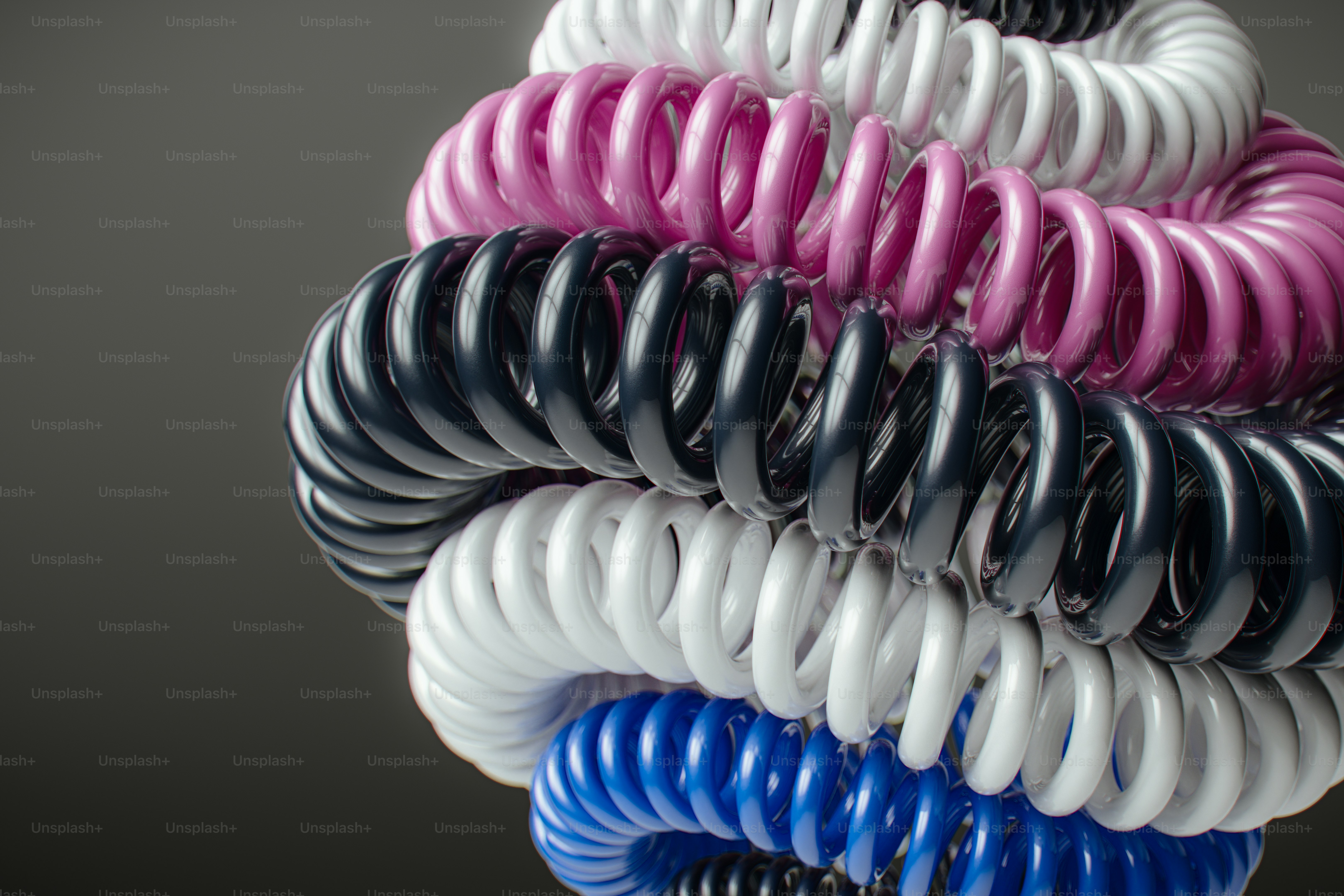 Stack of colorful coiled springs on dark background