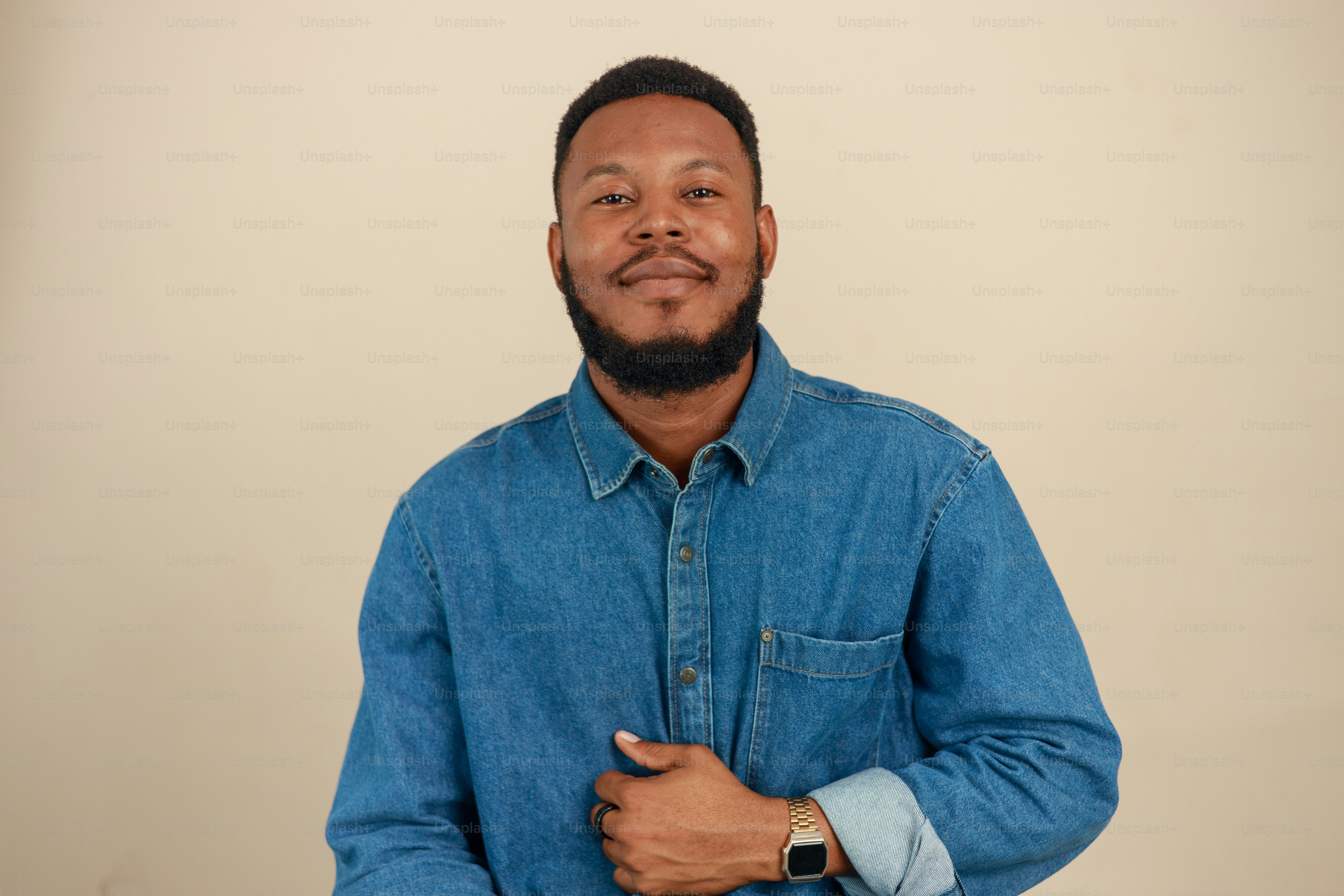 A smiling man in a denim shirt