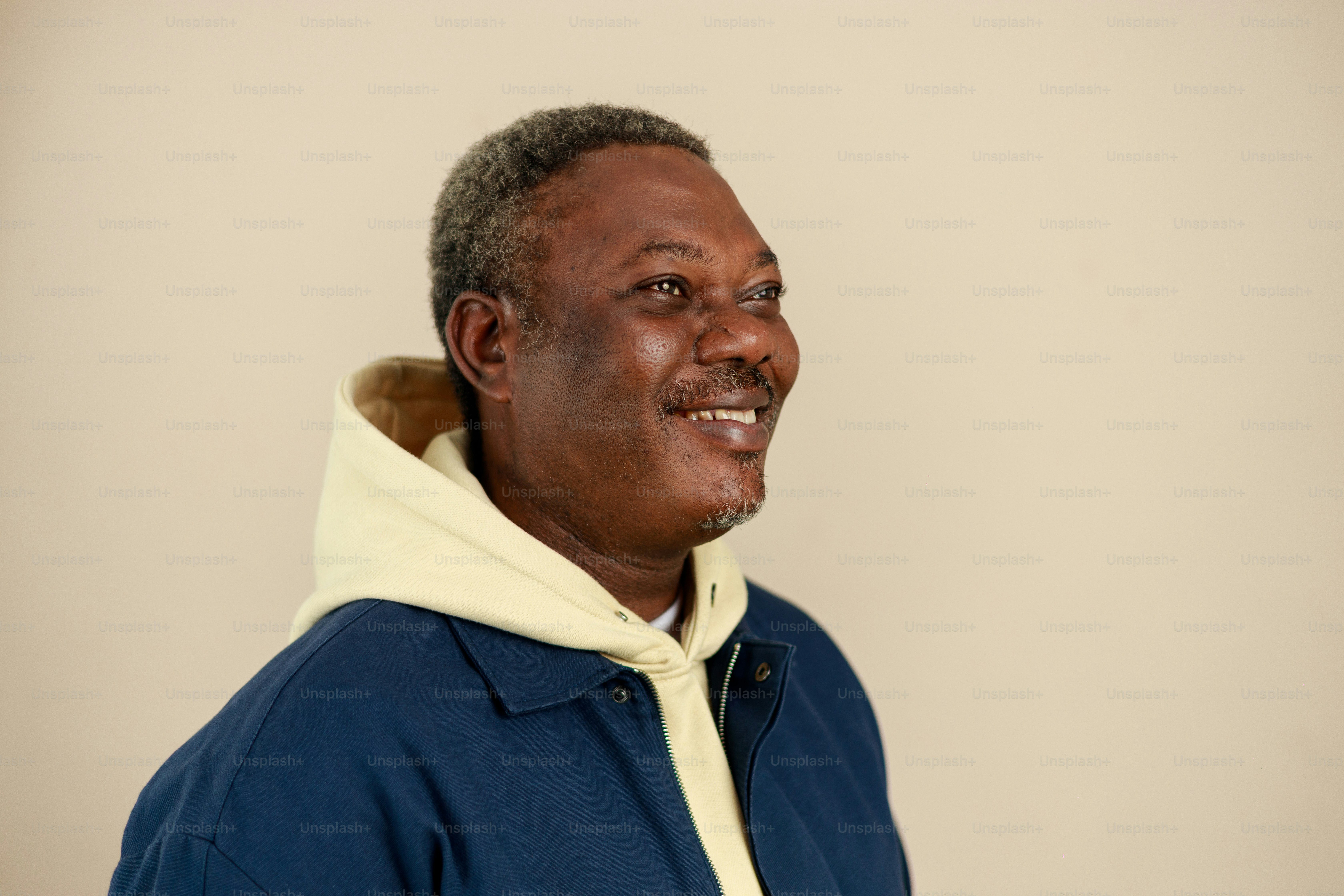 Smiling older black man wearing a blue jacket and hoodie