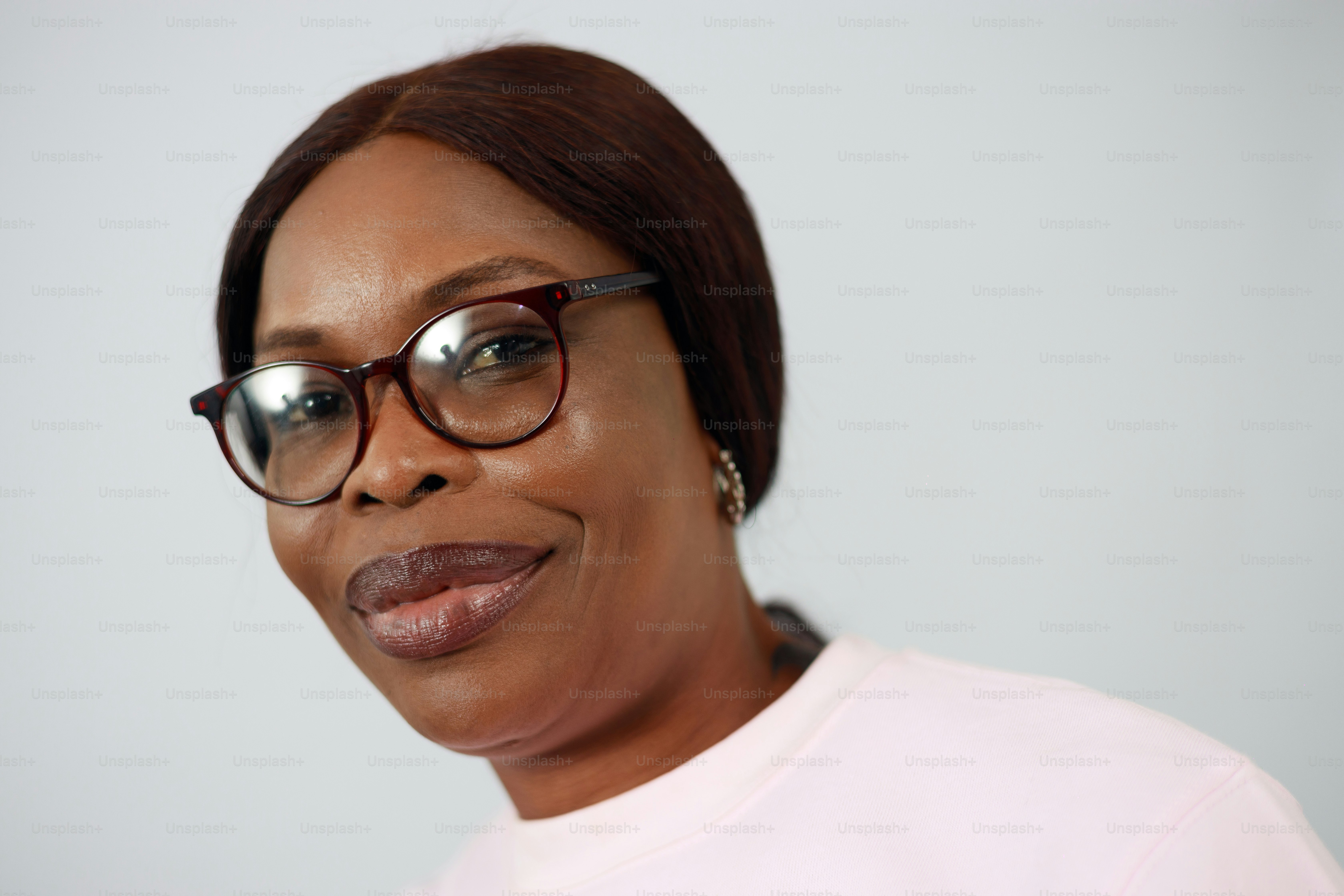 A woman with glasses smiles softly