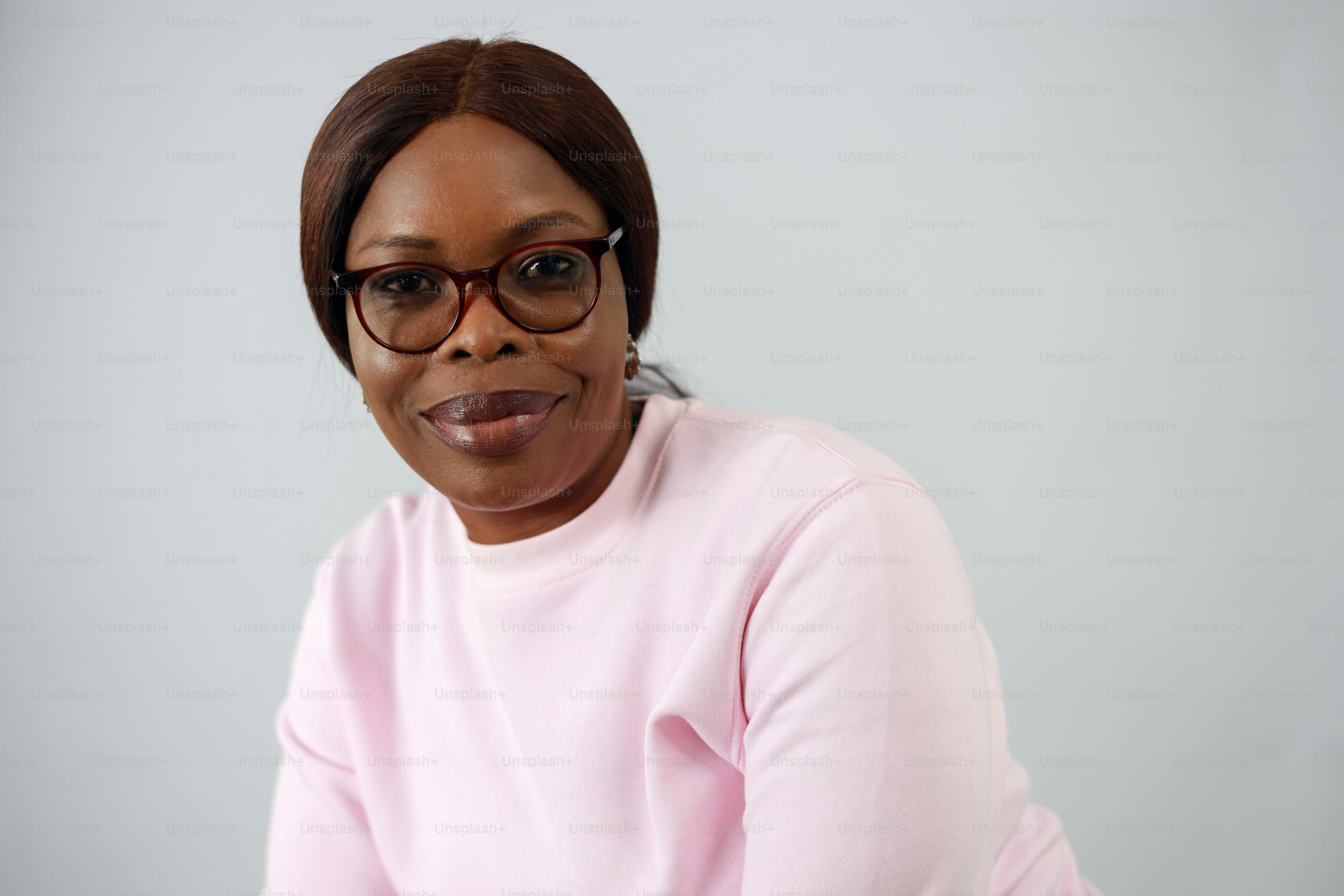 A woman wearing glasses and a pink sweater