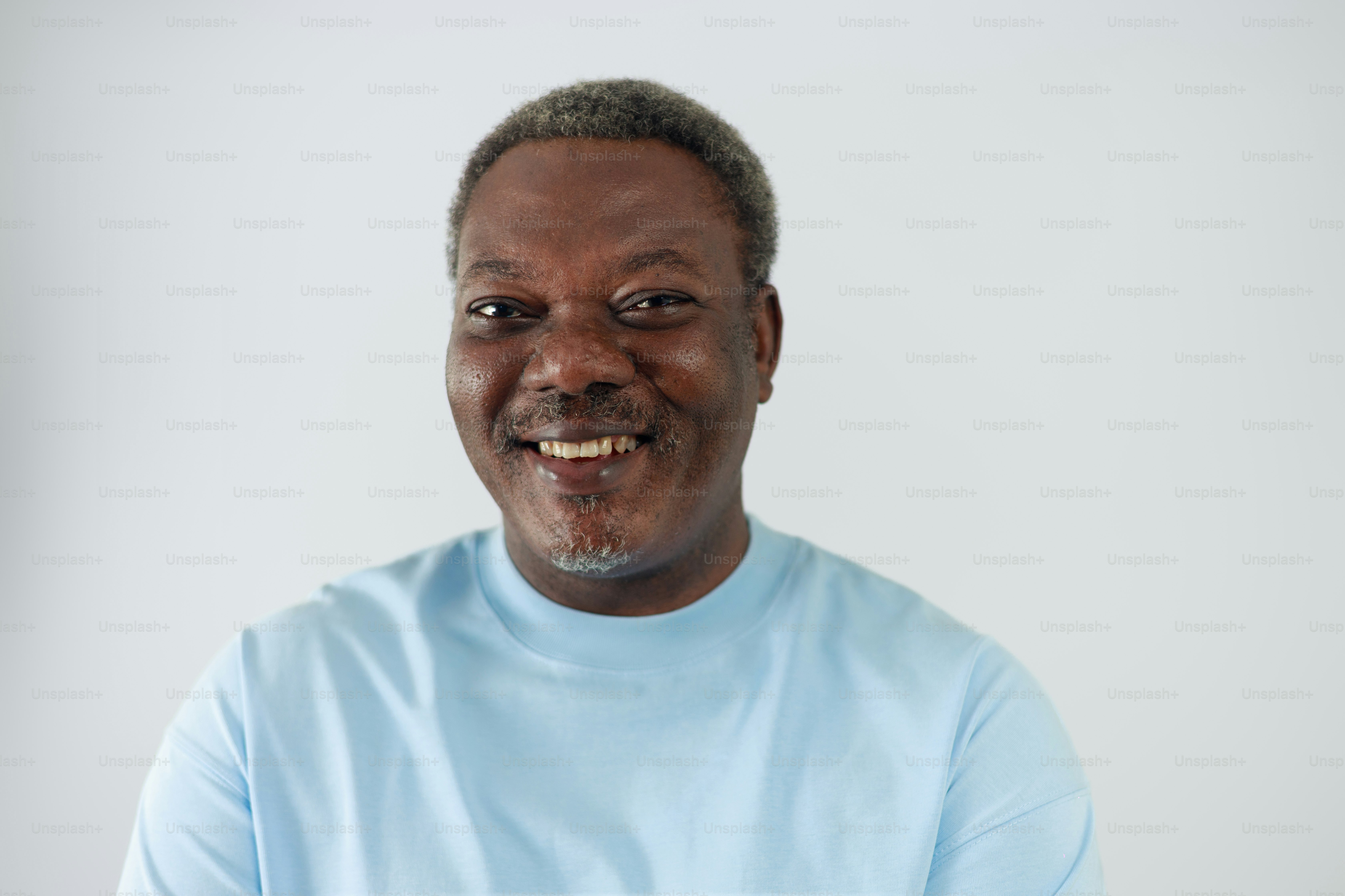 A smiling black man in a light blue shirt