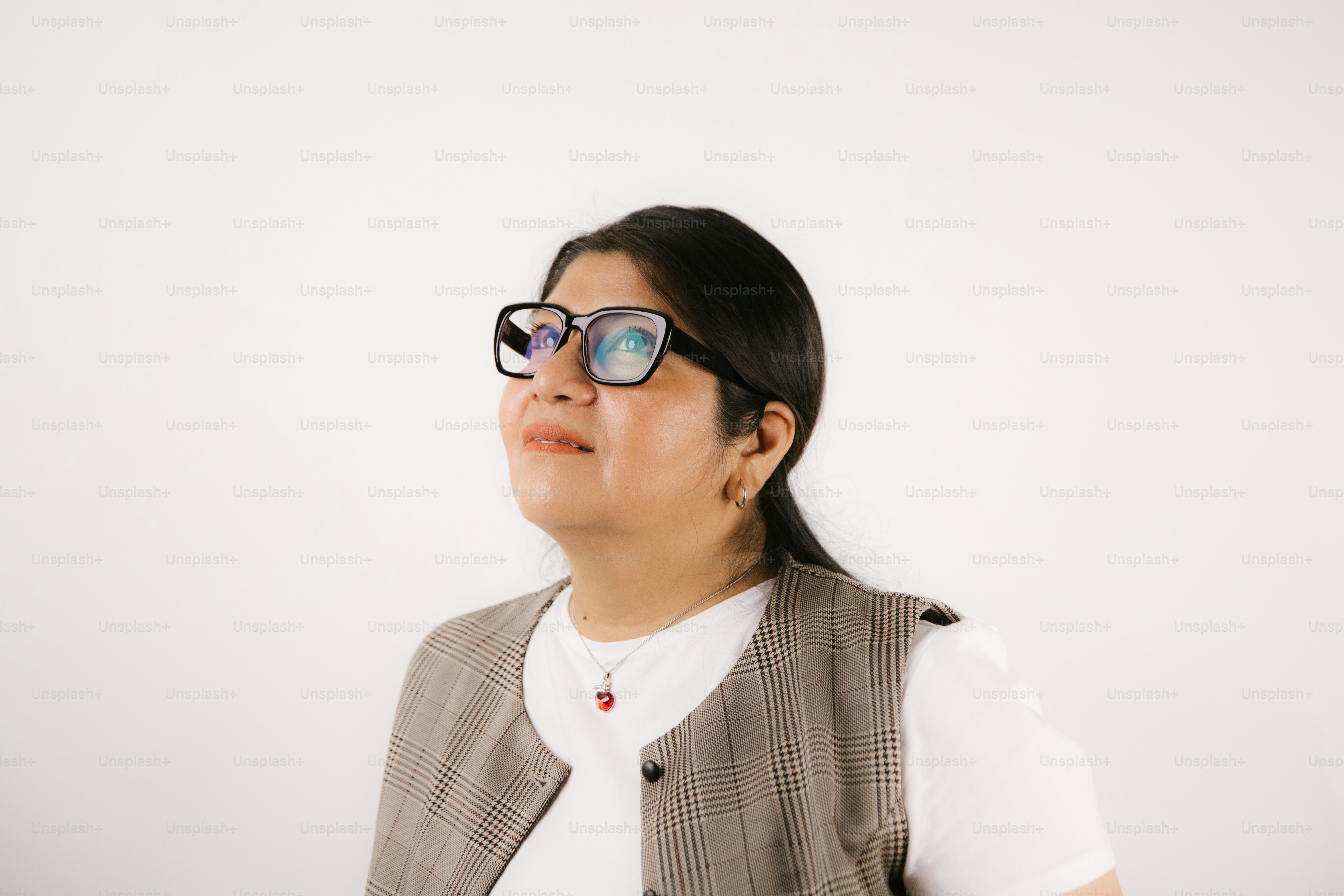 A woman wearing glasses looks up