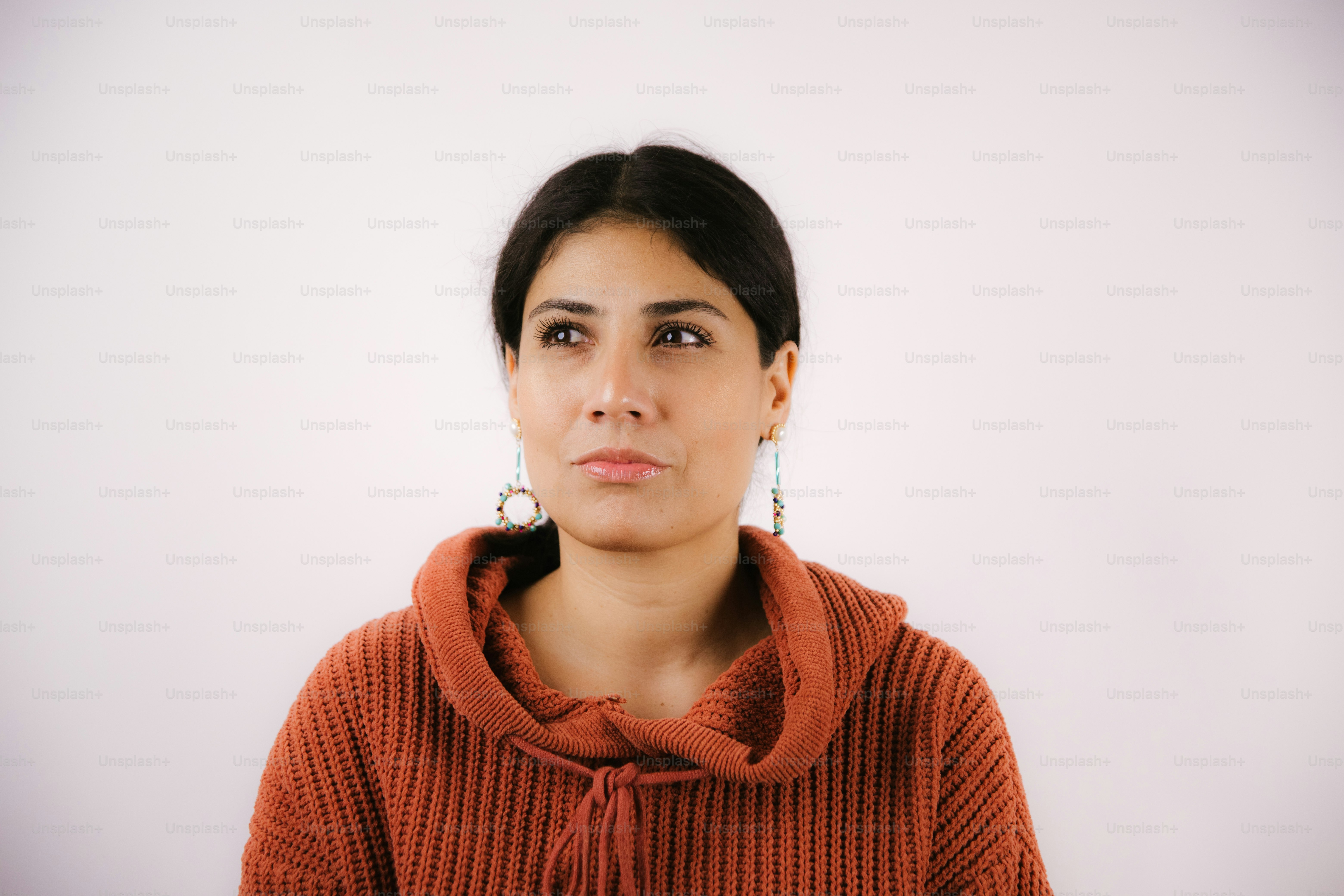 A young woman with dark hair wearing a rust-colored hoodie