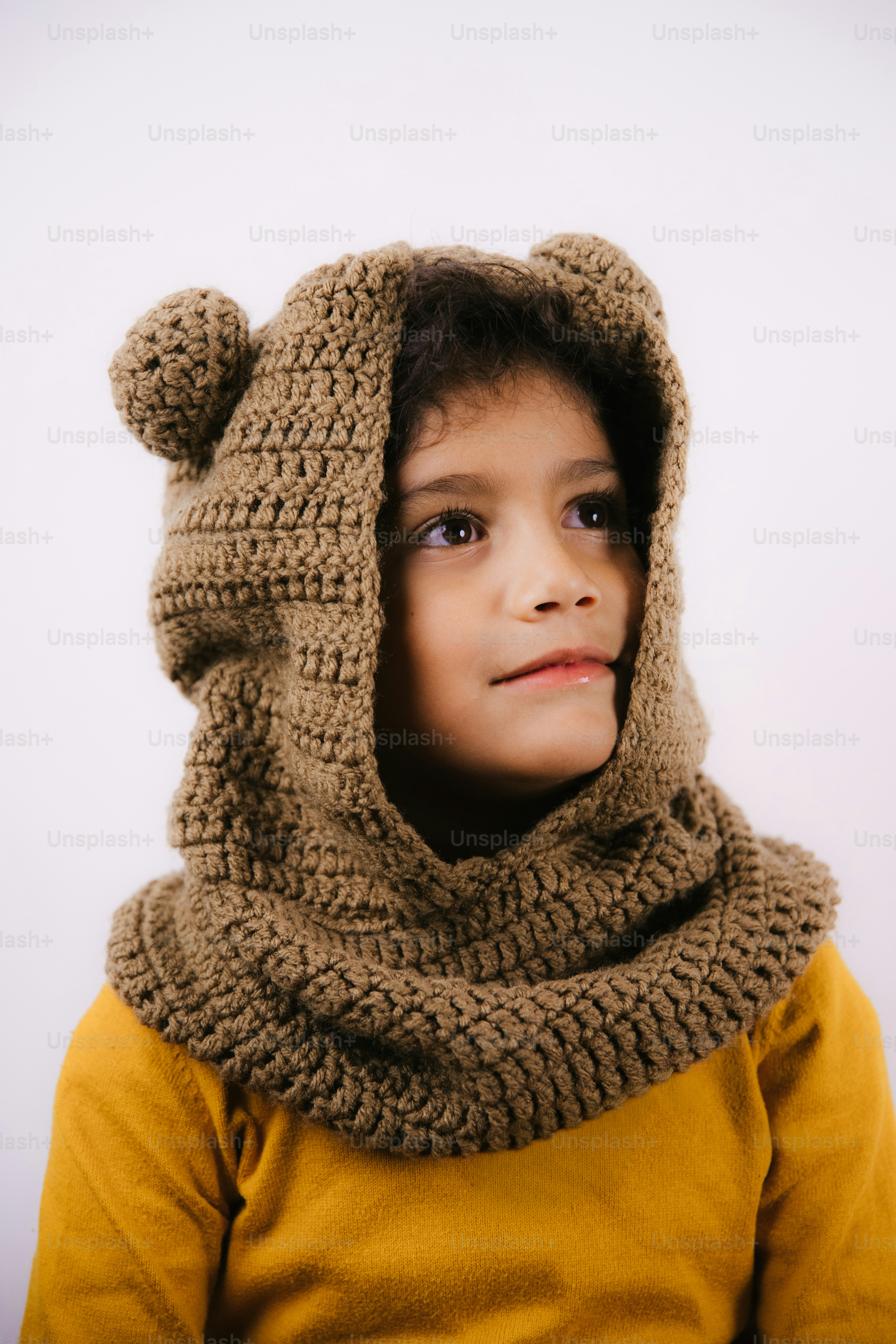 Child wearing a brown crocheted bear hood