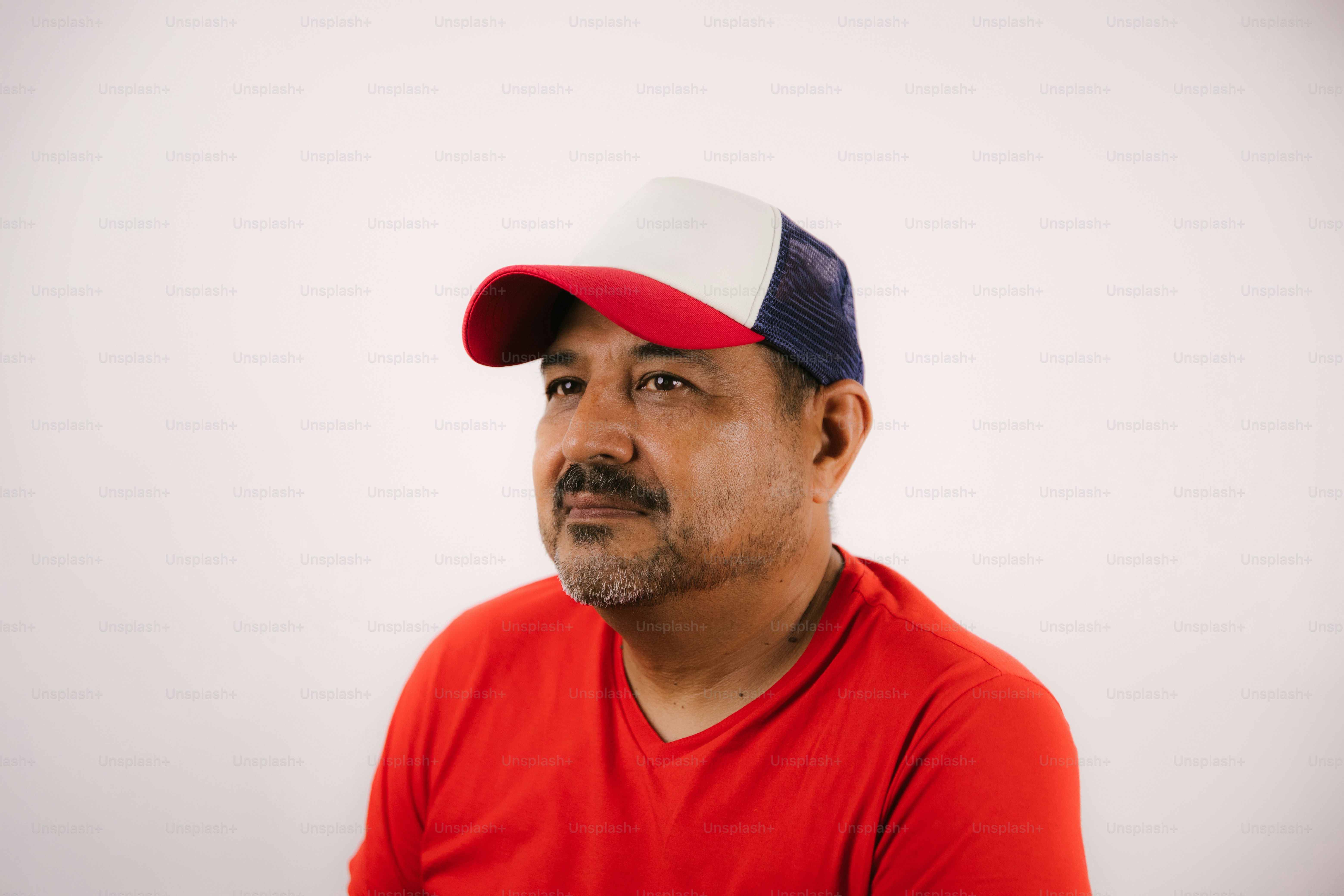 Homem vestindo uma camisa vermelha e um chapéu tricolor