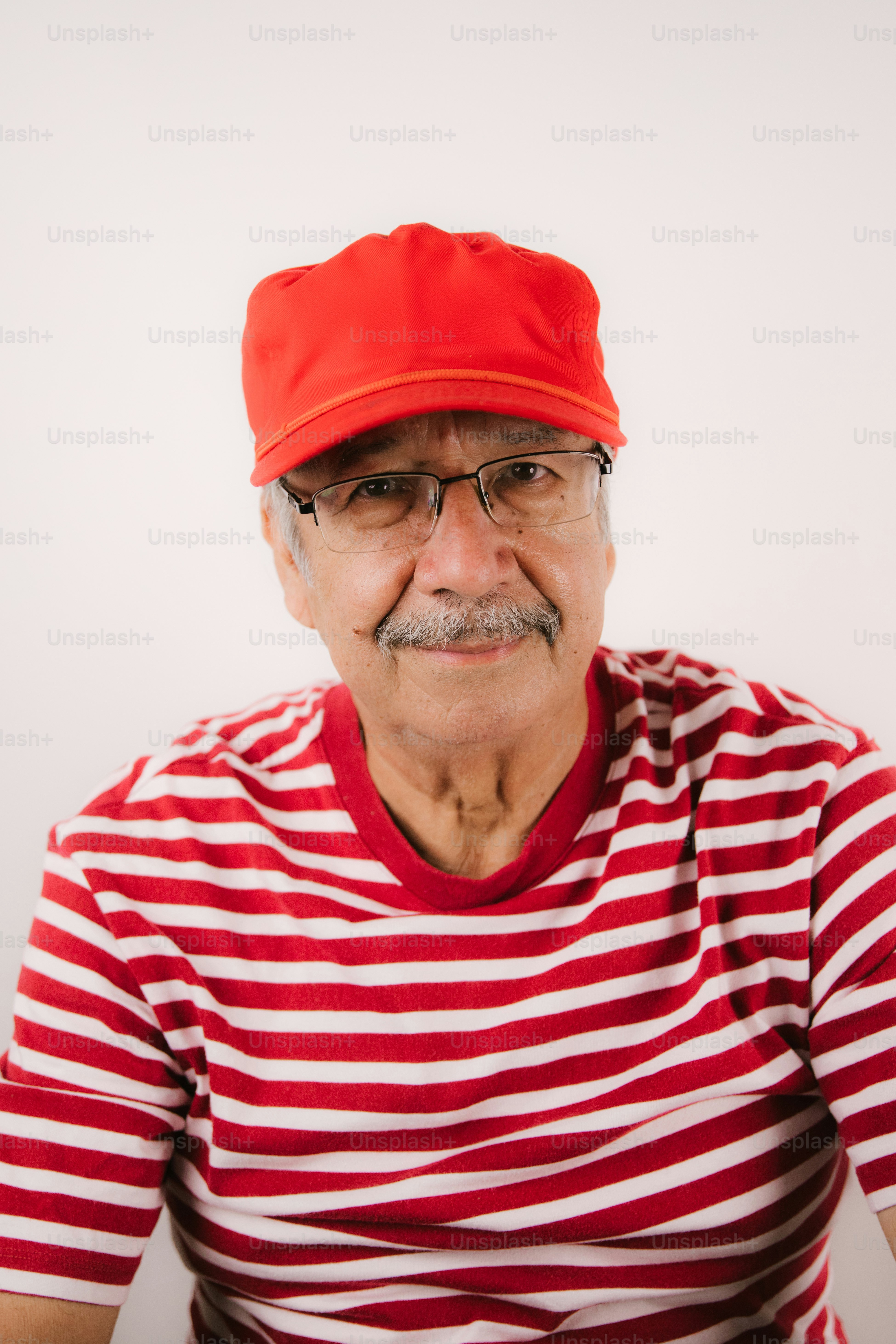 Elderly man wearing red cap and striped shirt