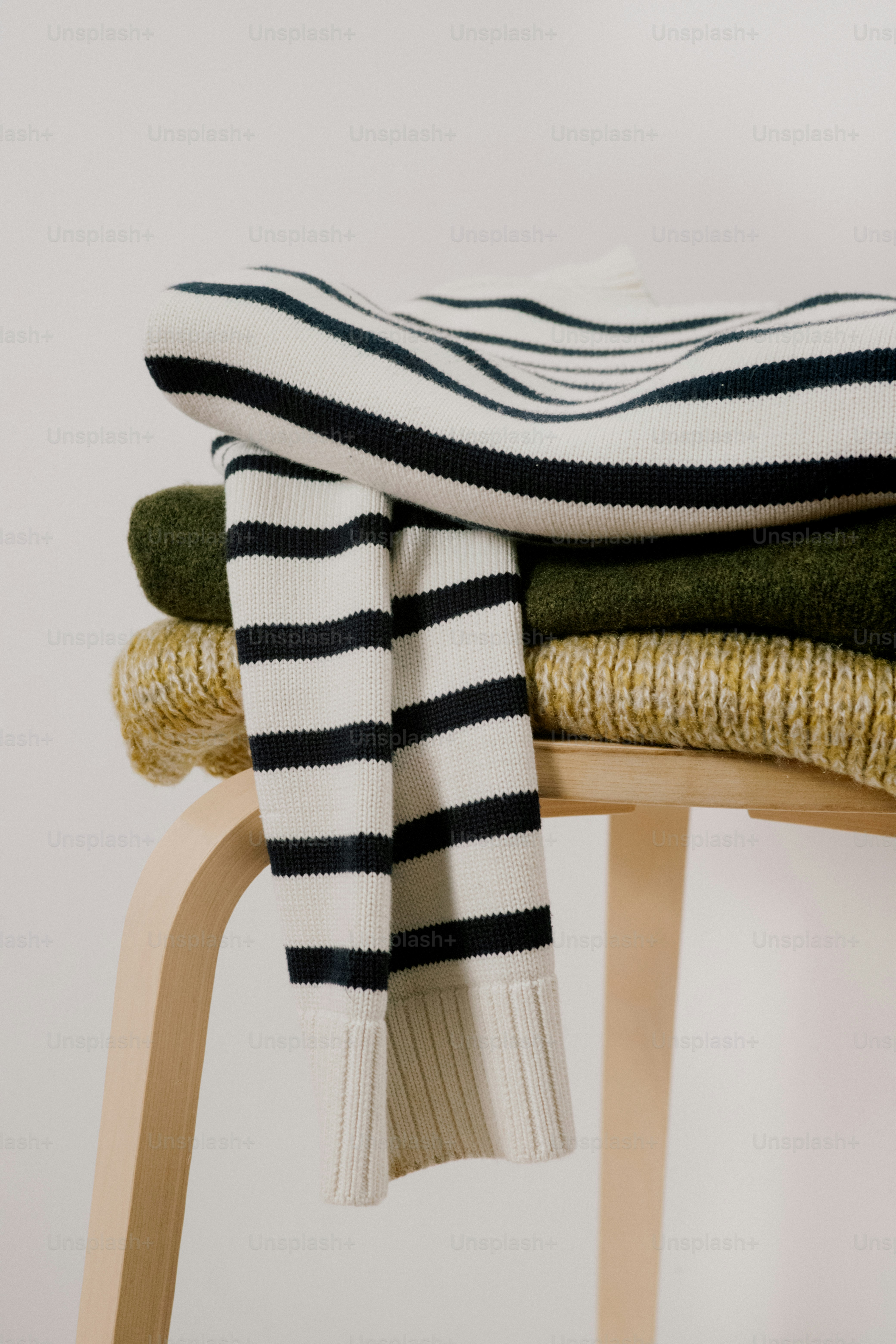 Stack of neatly folded sweaters with stripes.