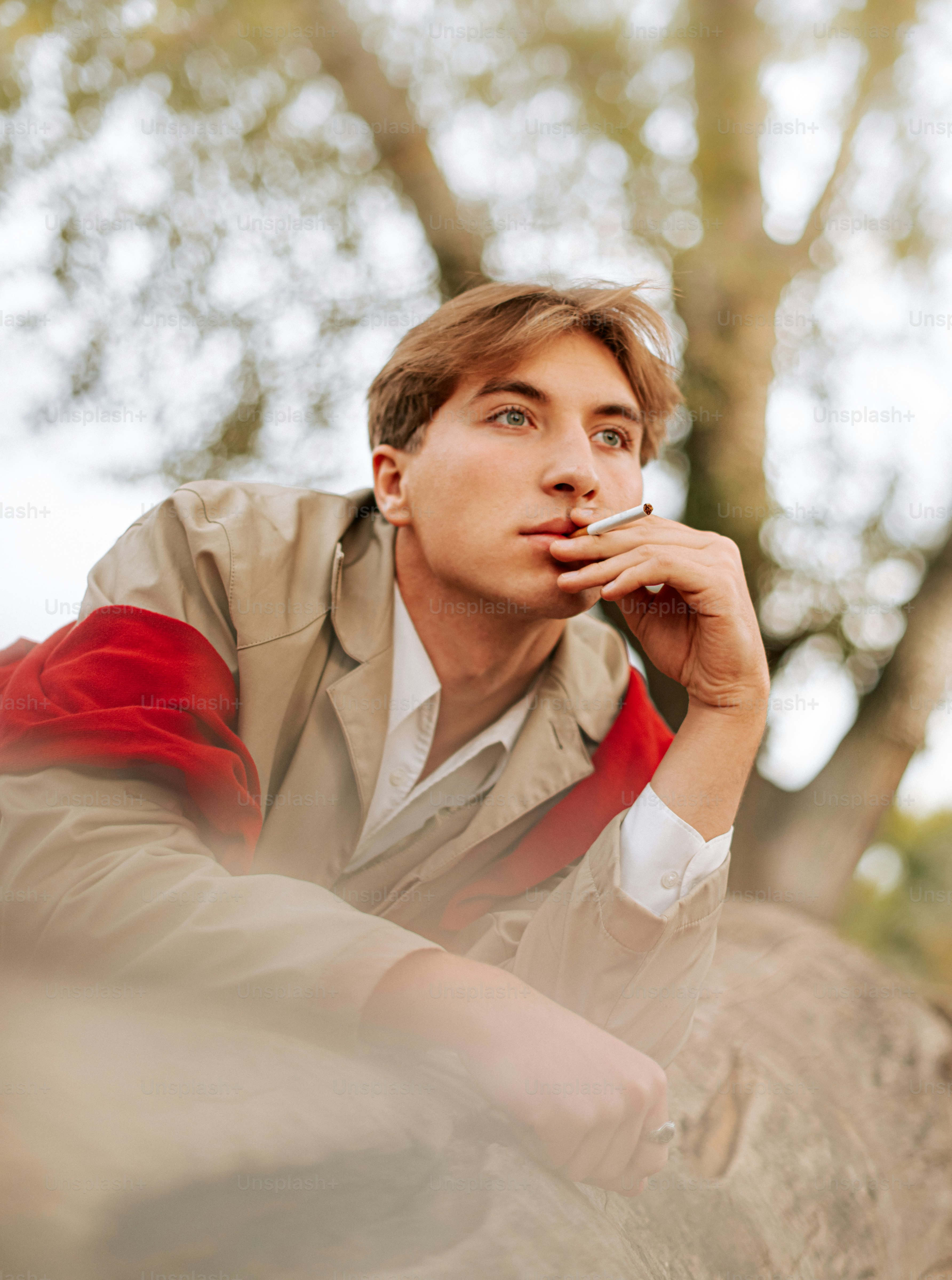 Young man holding a cigarette outdoors