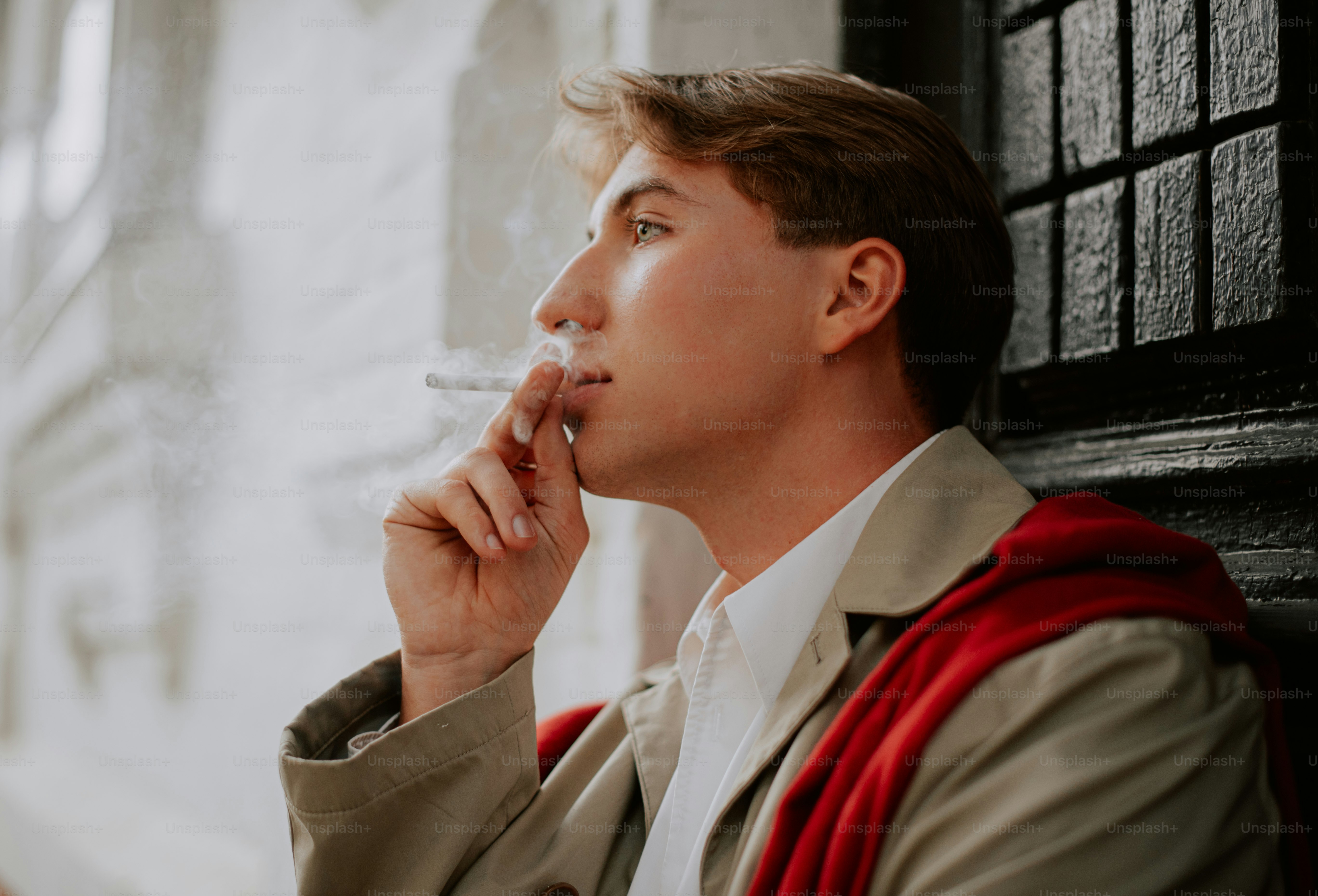 Junger Mann, der im Freien eine Zigarette raucht.