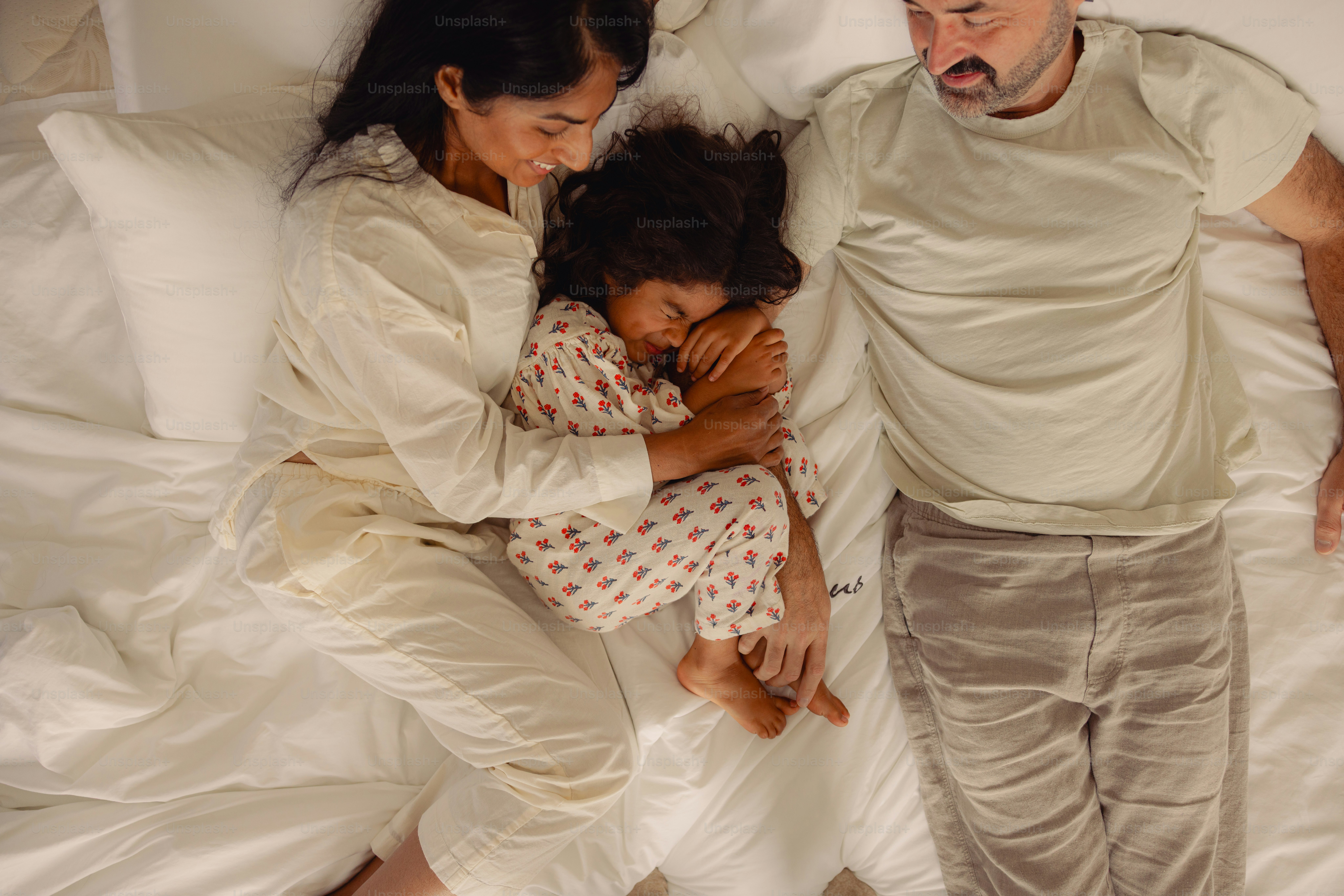 Familie schläft friedlich zusammen im Bett