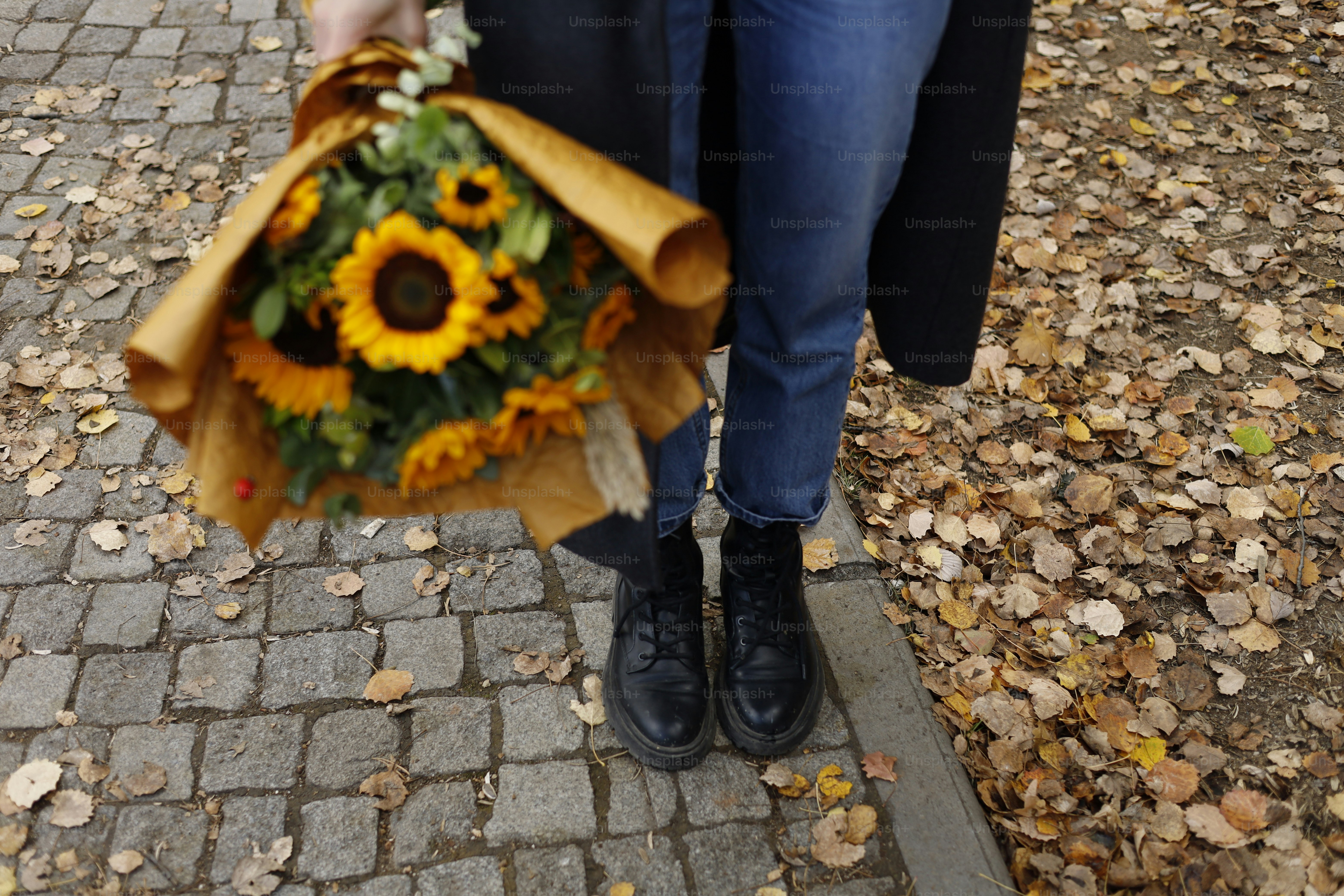 Pessoa segurando um buquê de girassóis ao ar livre