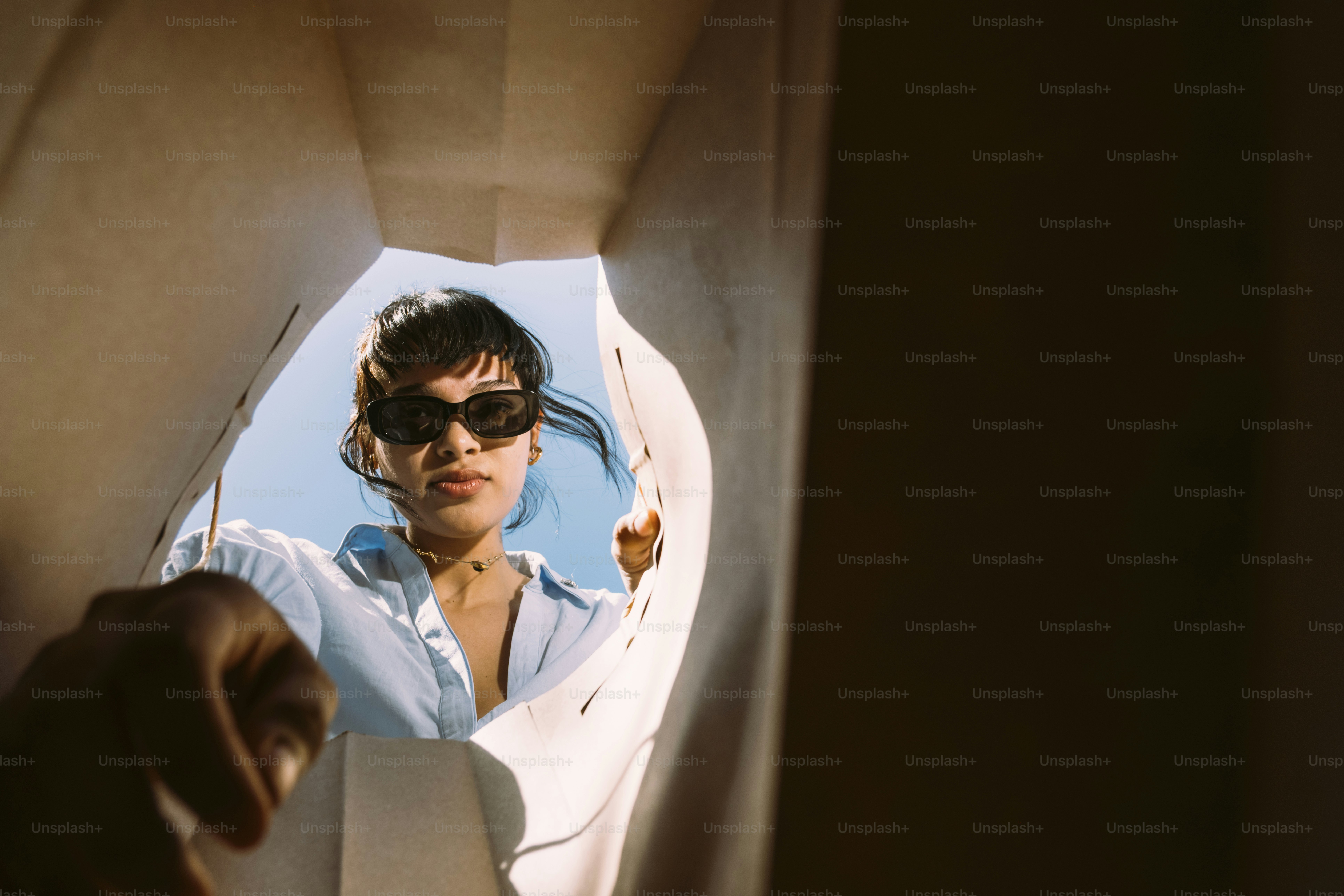 Frau, die von unten in eine Papiertüte schaut