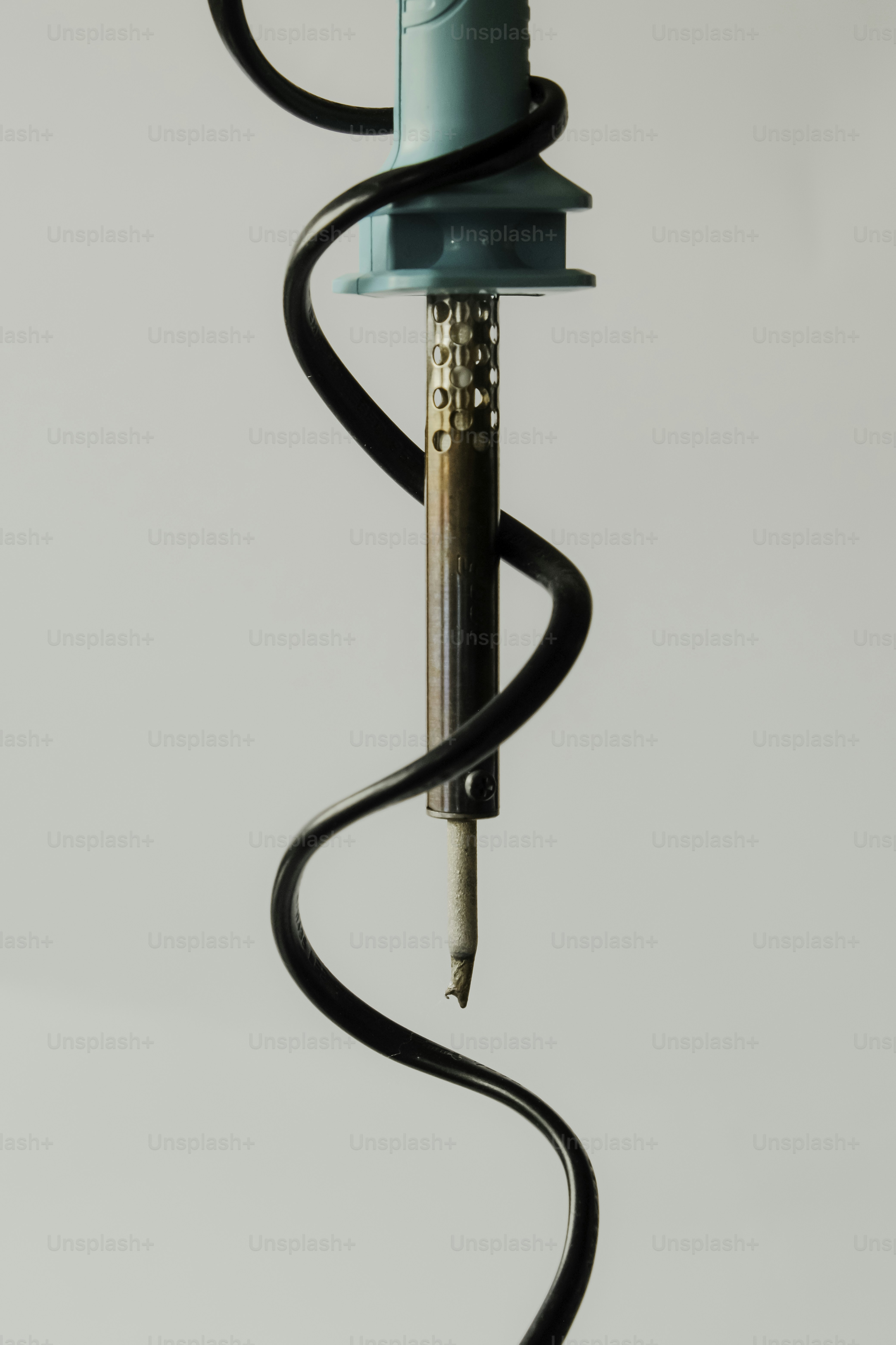 Soldering iron with a coiled black cord