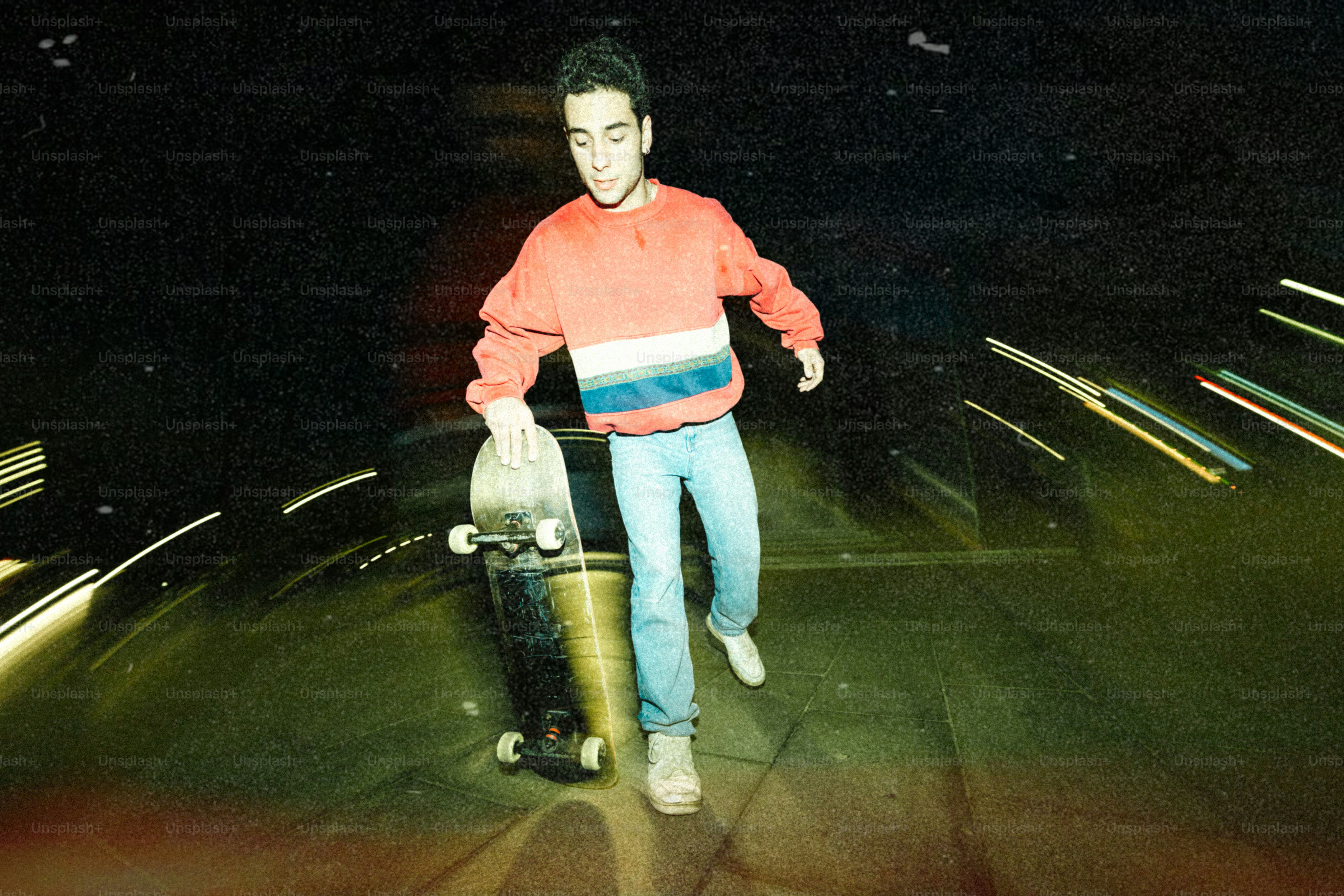 Joven con monopatín por la noche