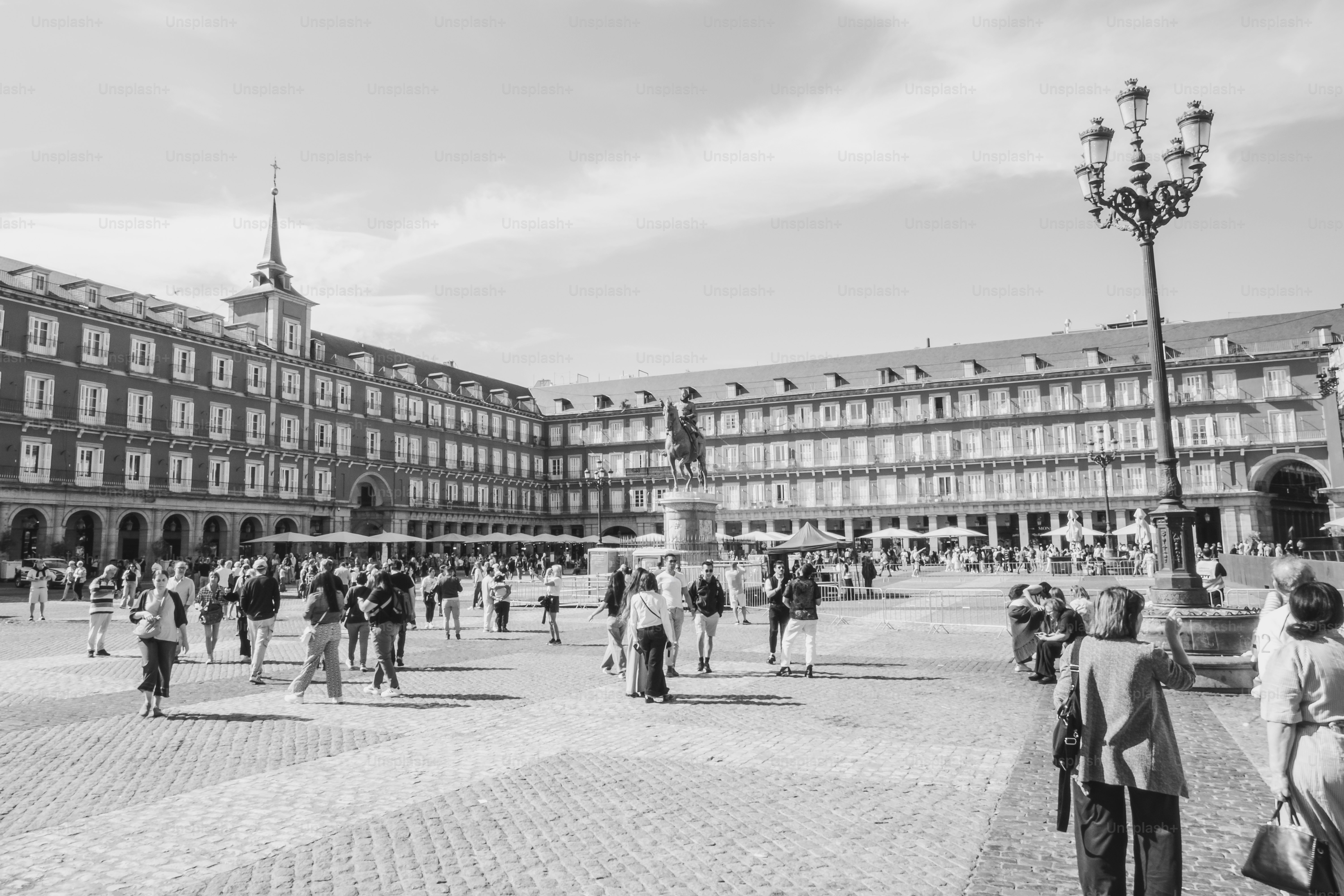 People strolling through a large european plaza with historic buildings.