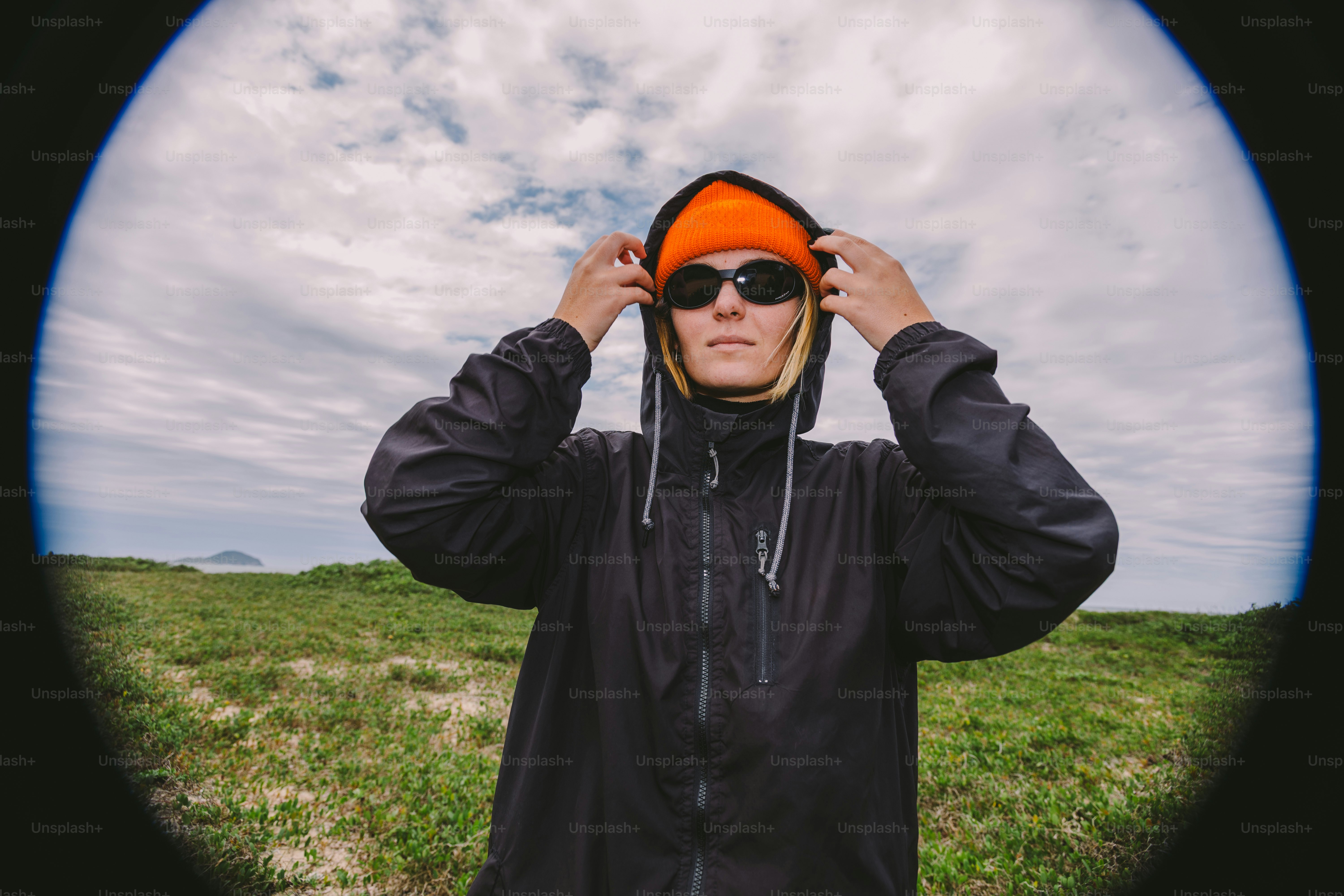Person in jacket and beanie adjusting hood outdoors photo – Travel ...