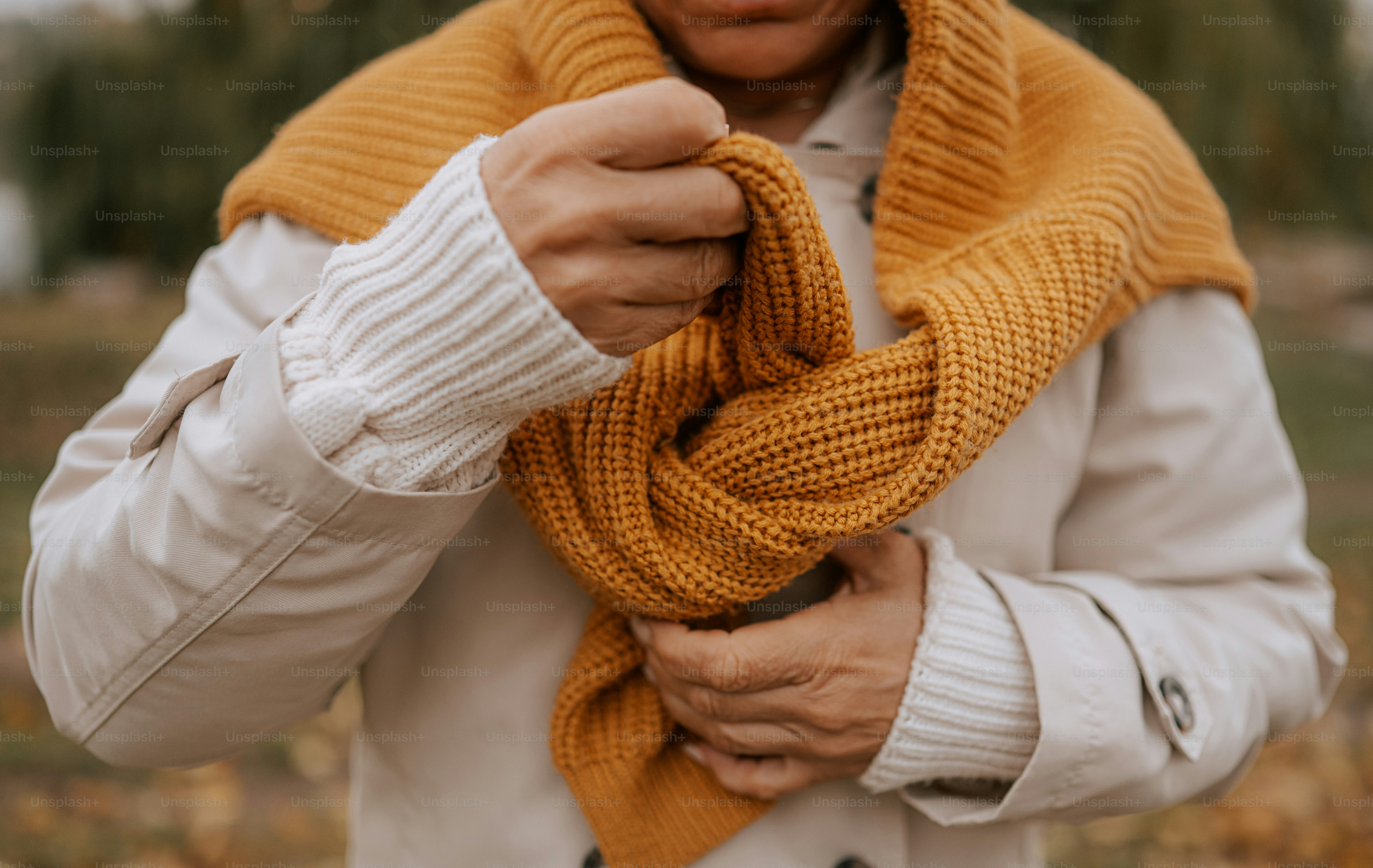 Personne ajustant une écharpe tricotée jaune