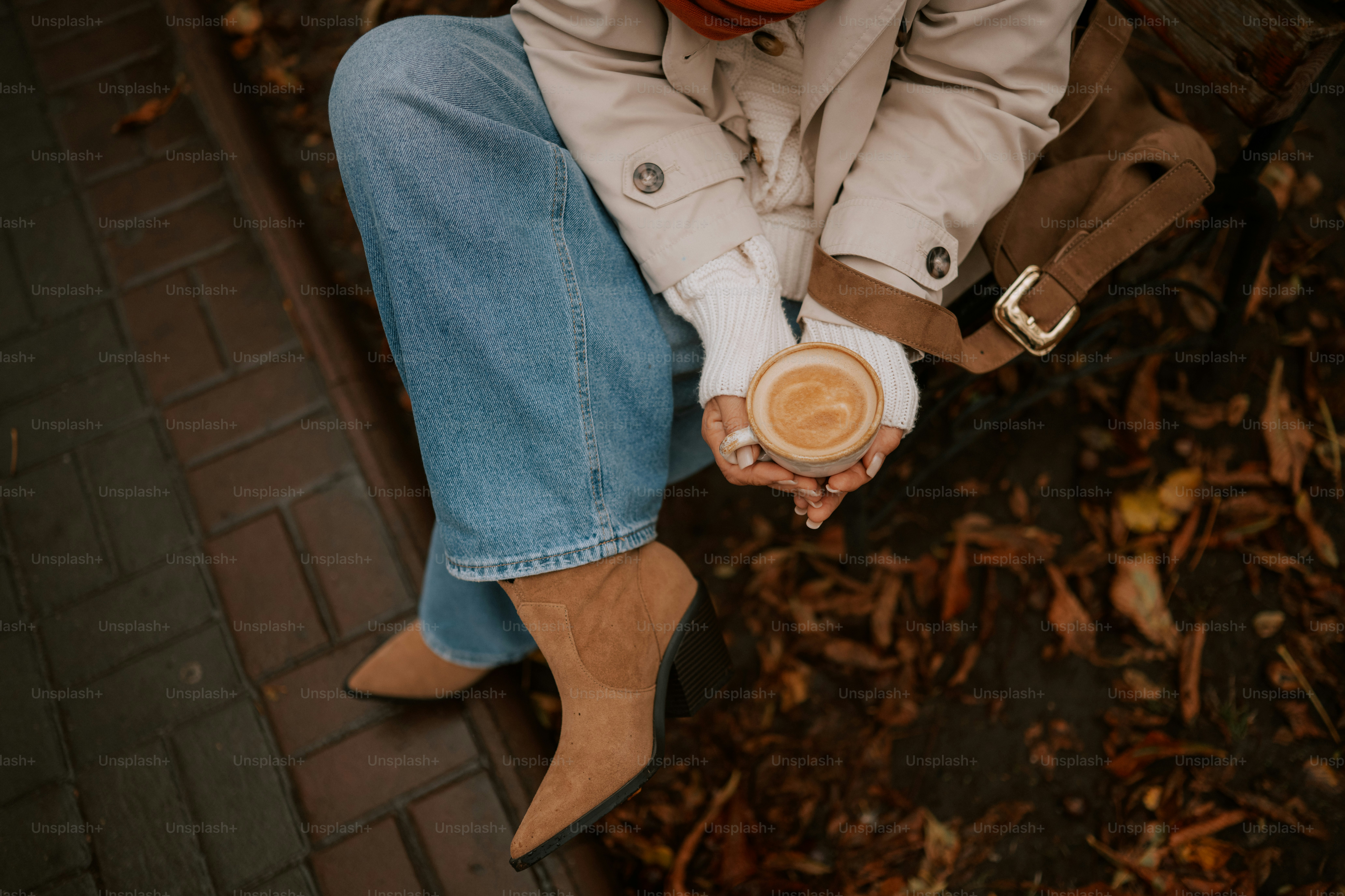 Femme tenant une tasse à café avec des feuilles d’automne