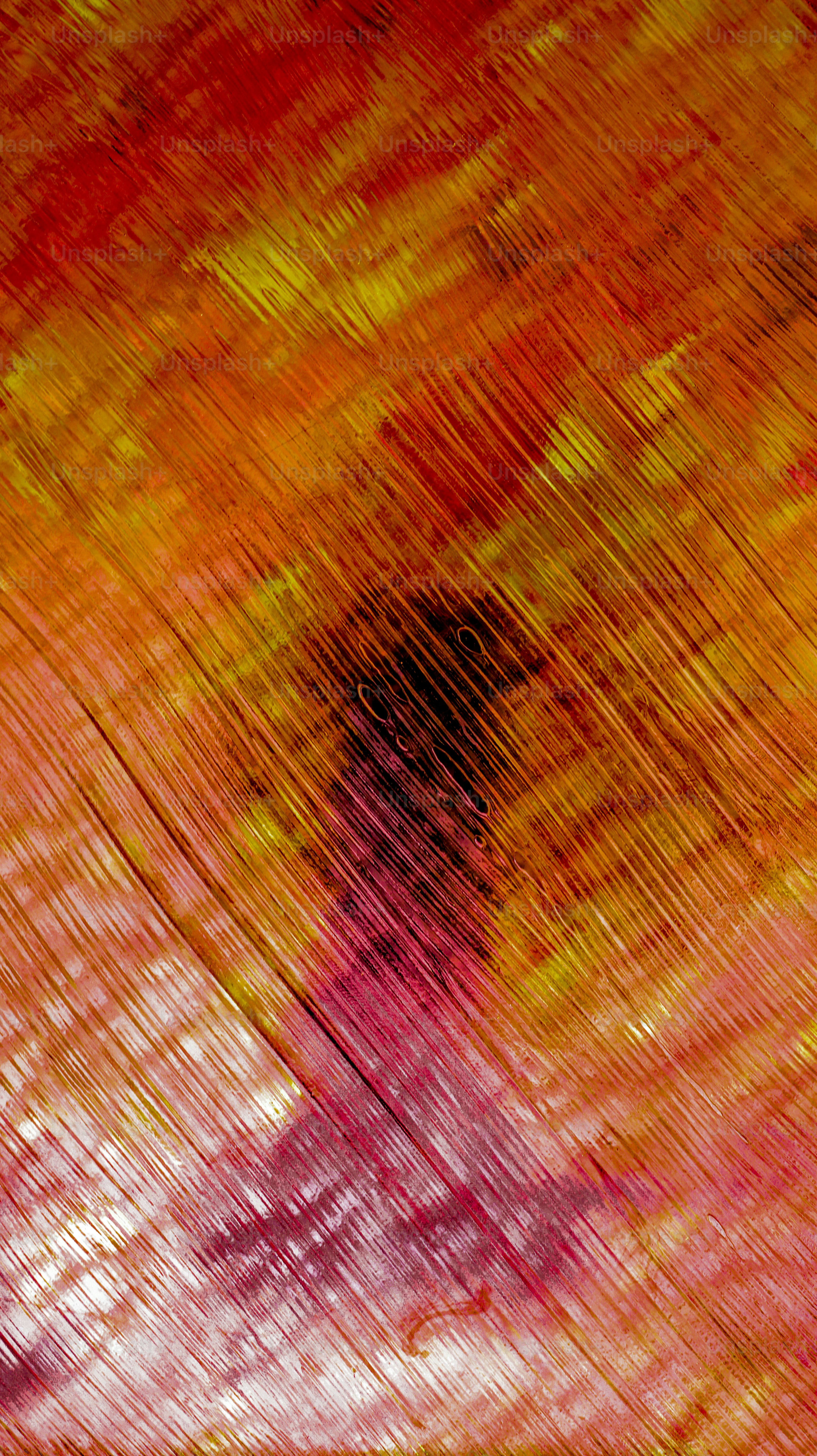 Abstract textured background with red, yellow, and pink hues.