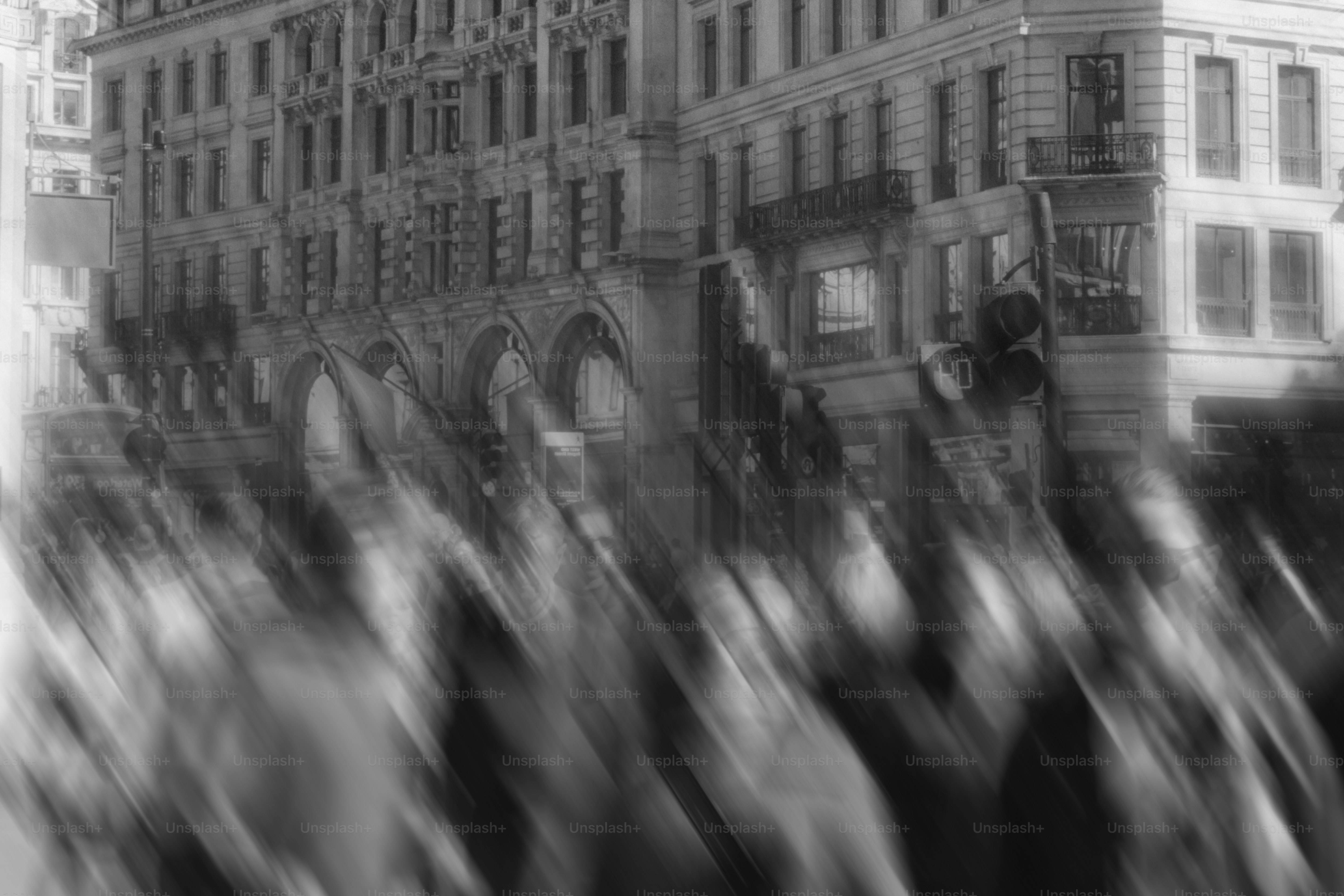 Blurred figures walk past ornate buildings.