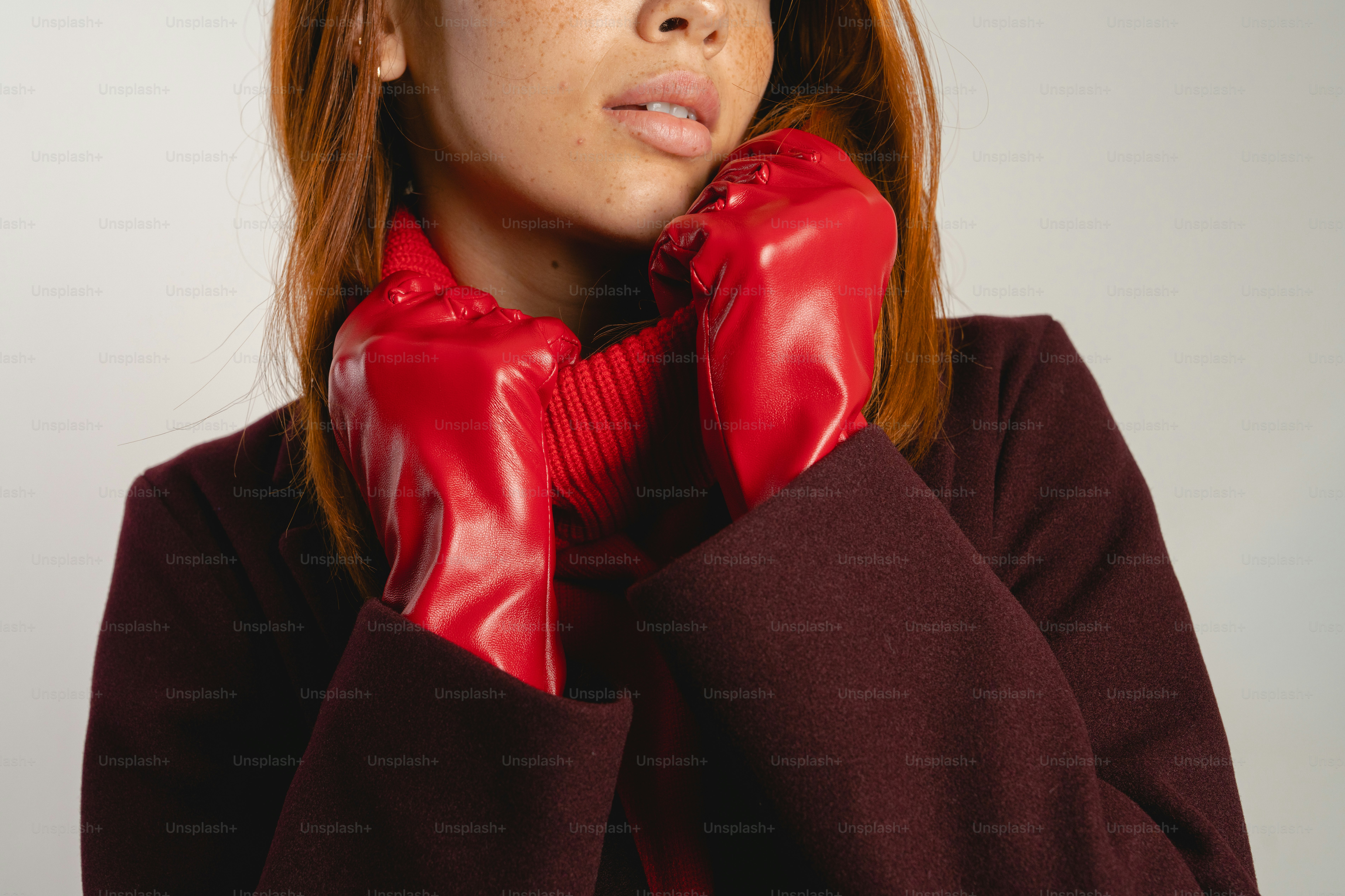 Woman wearing red gloves and maroon coat