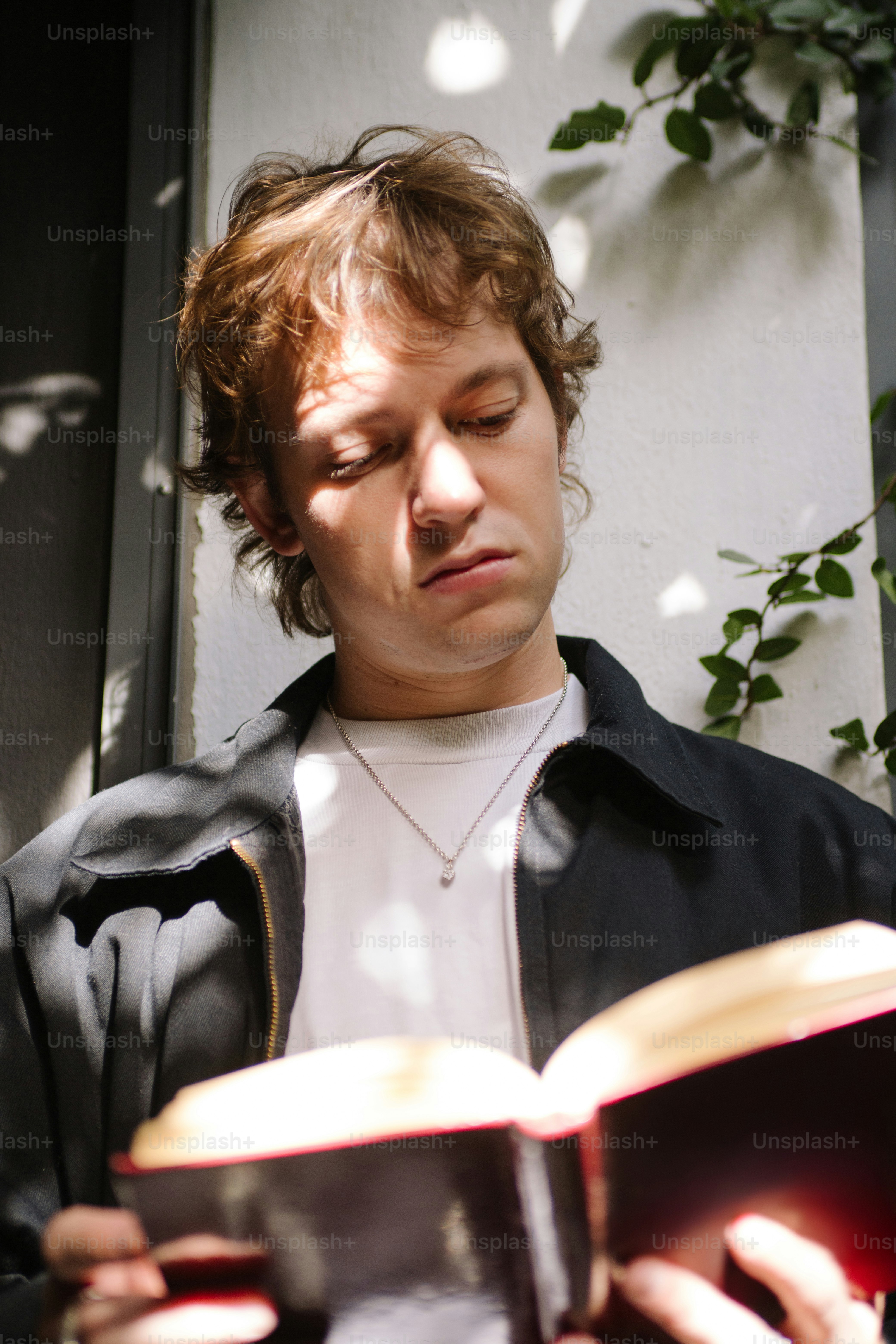 Young man reading a book outdoors