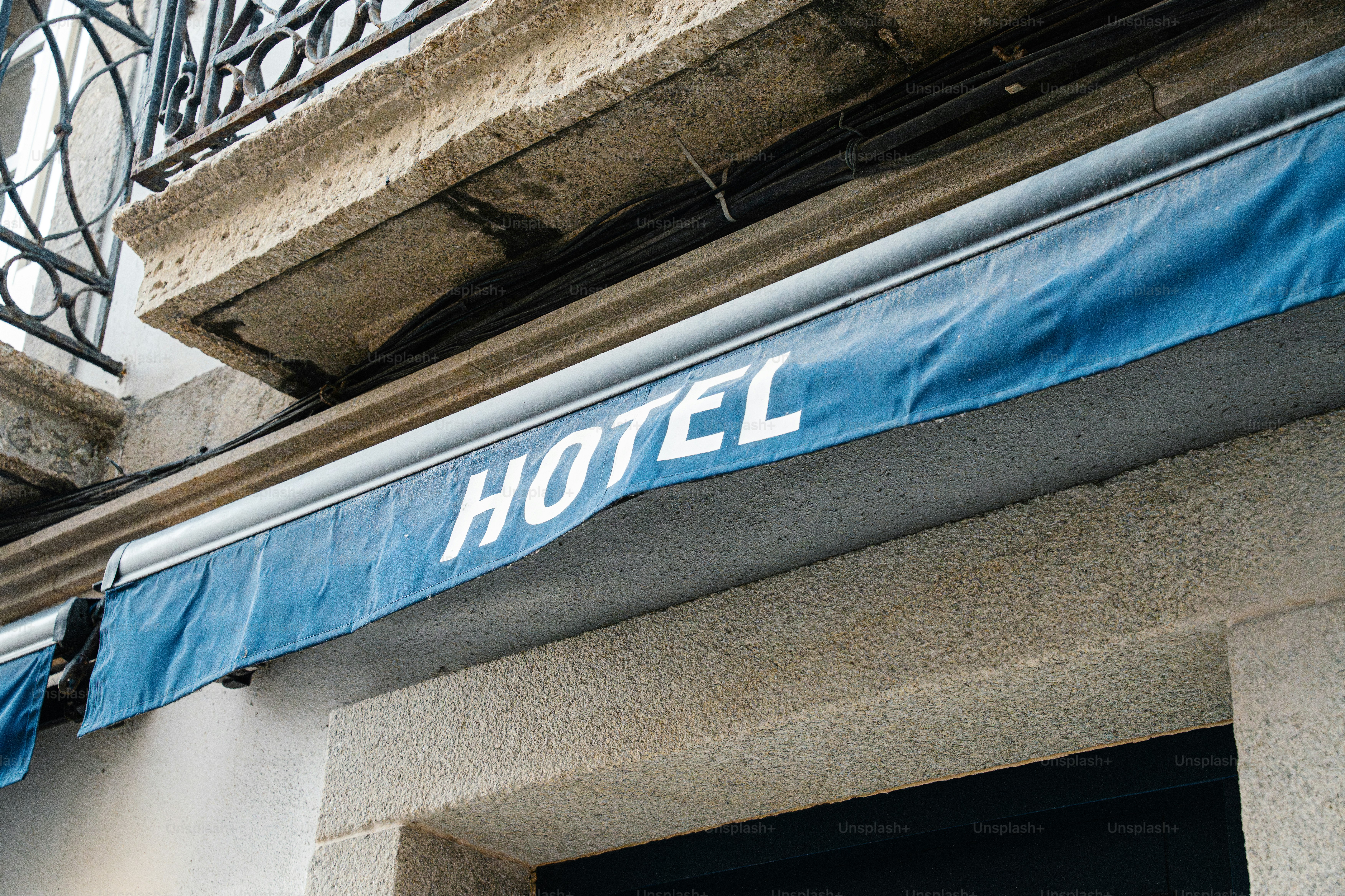 Blue awning with the word hotel in white letters.