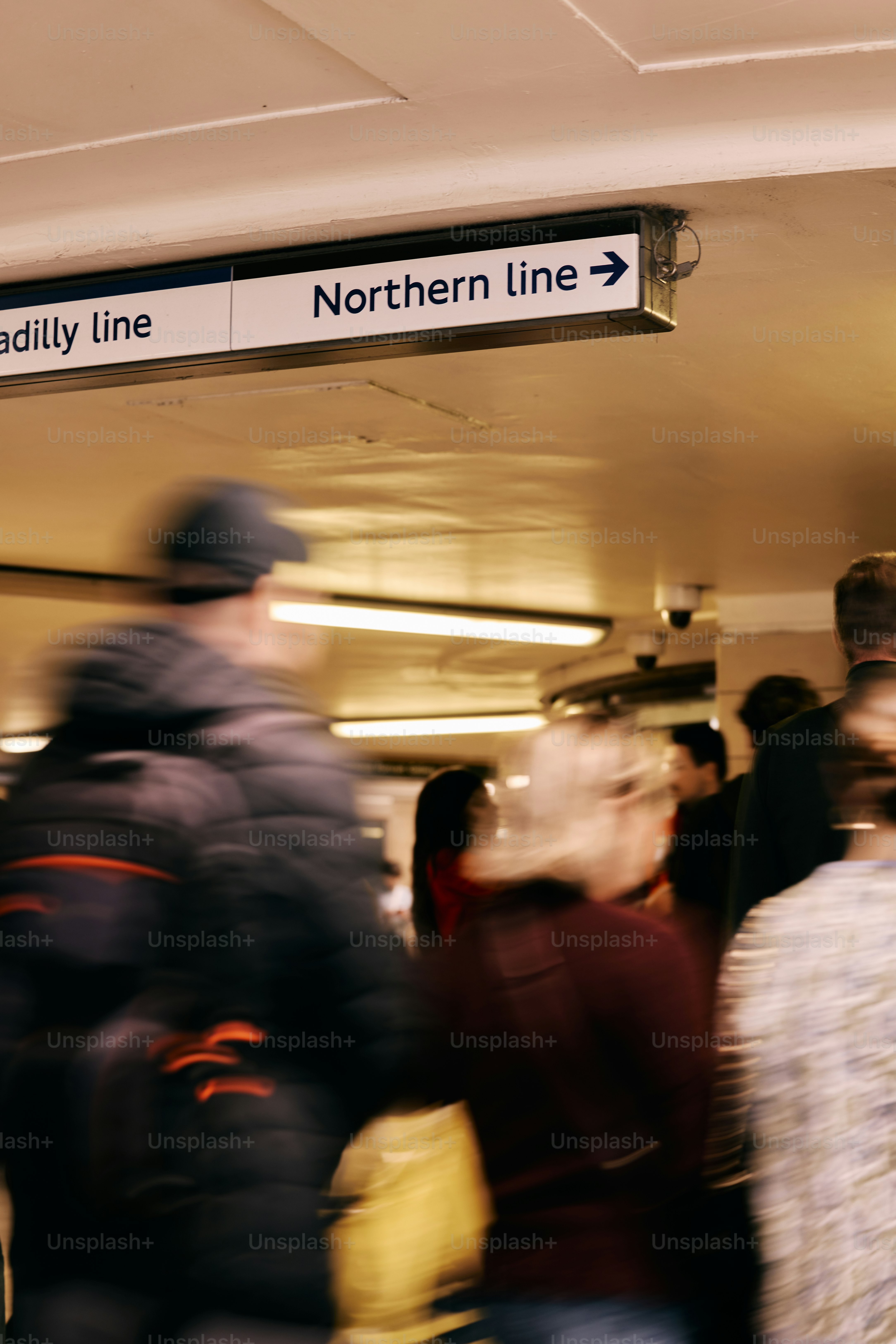 Menschen, die an einem Schild für die nördliche Linie vorbeigehen