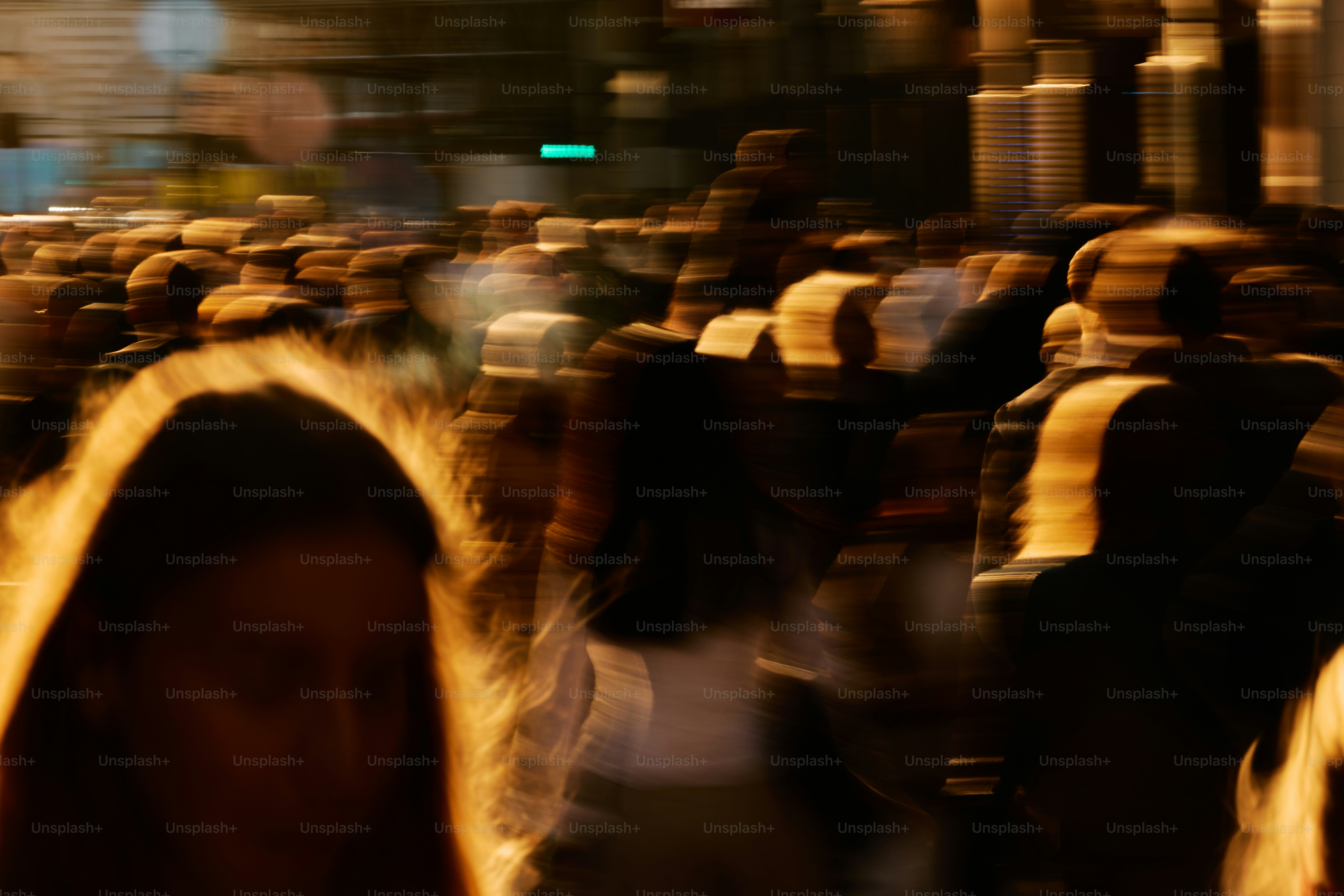 Multitud borrosa de personas caminando por la noche.