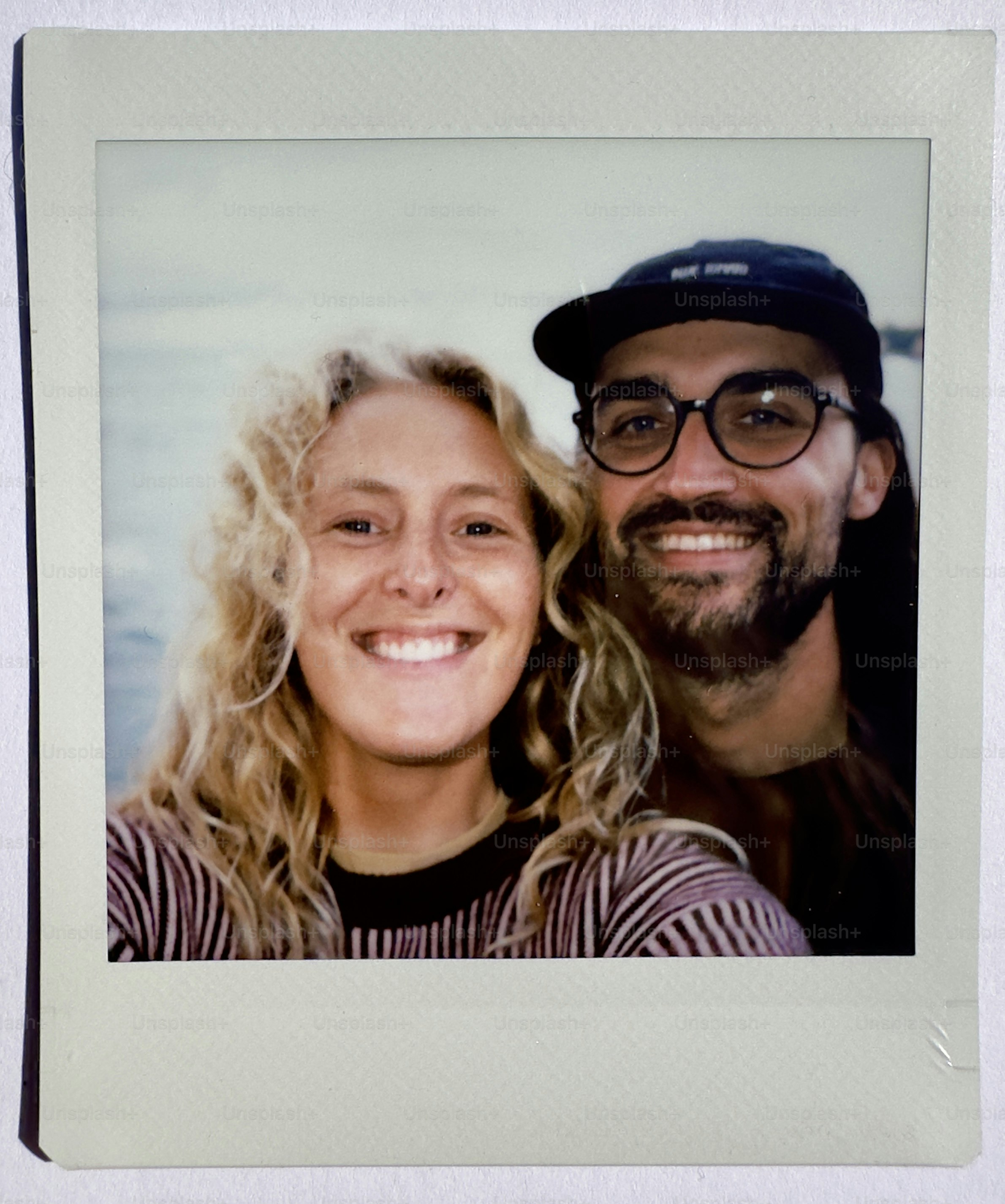 A smiling couple takes a selfie outdoors.