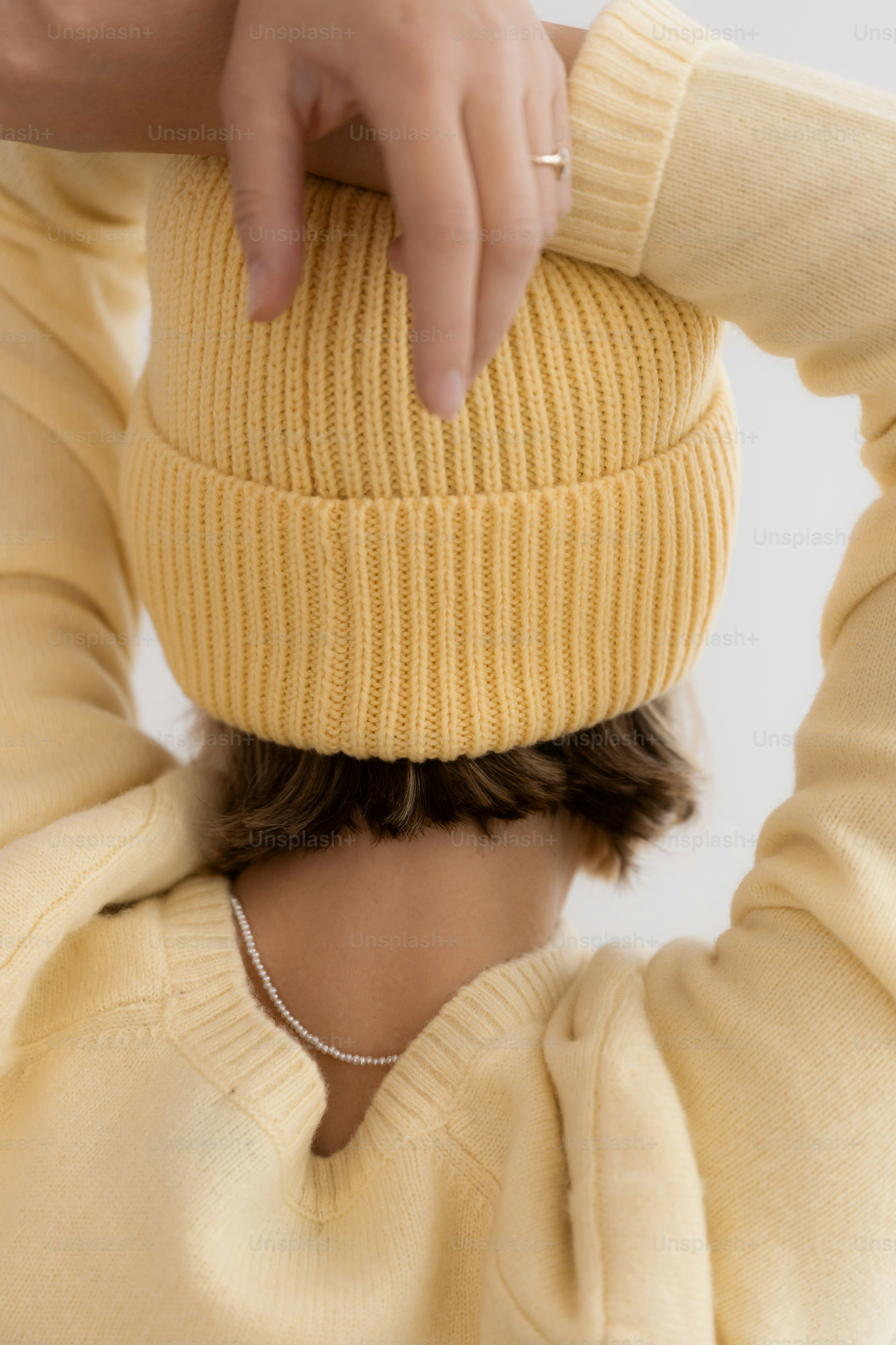 Pessoa vestindo um gorro amarelo e suéter