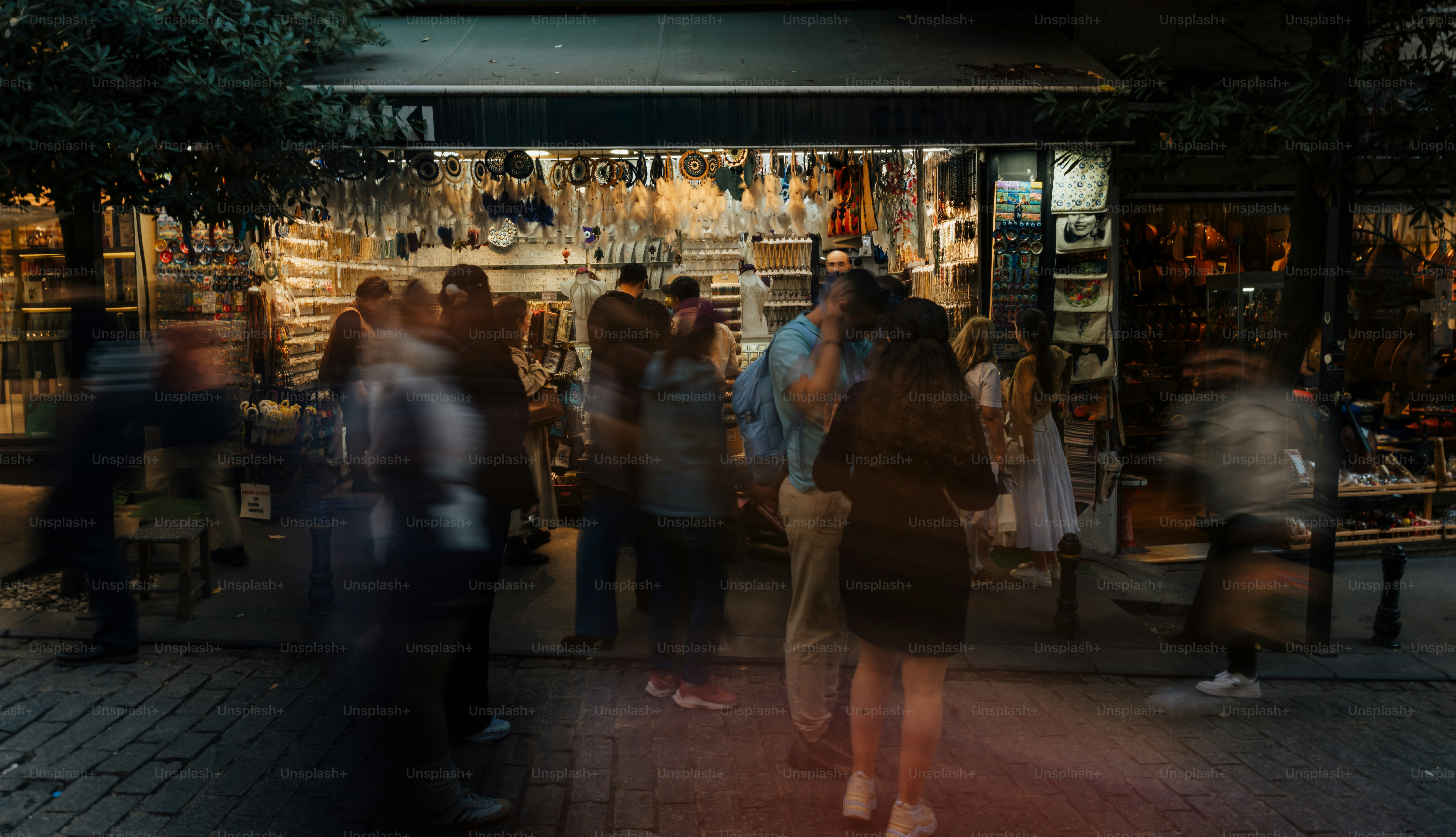 La nuit, des gens se mouvaient à l’extérieur d’un magasin.