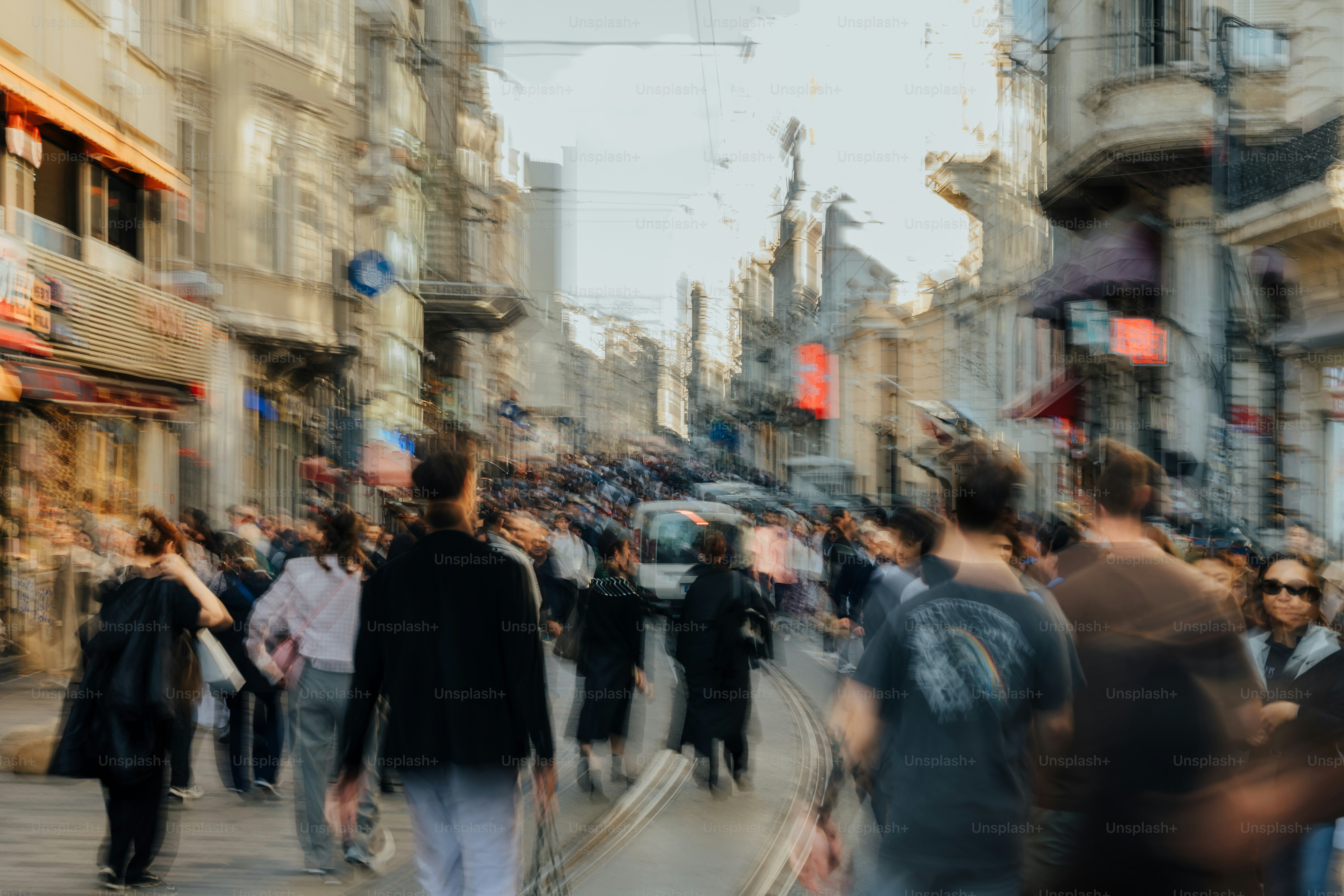 Blurred street scene with many pedestrians walking