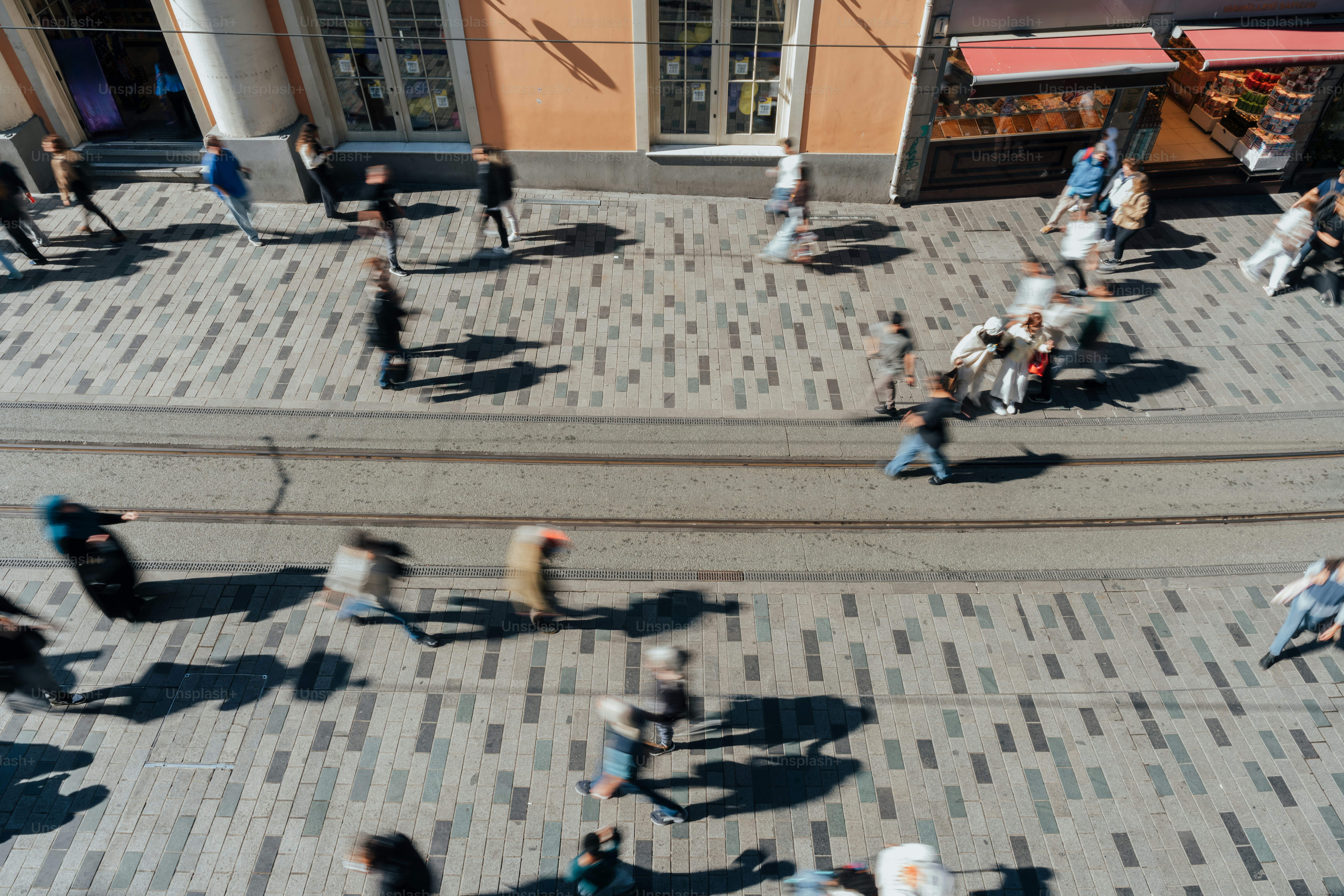 People walking on a cobblestone street with tram tracks