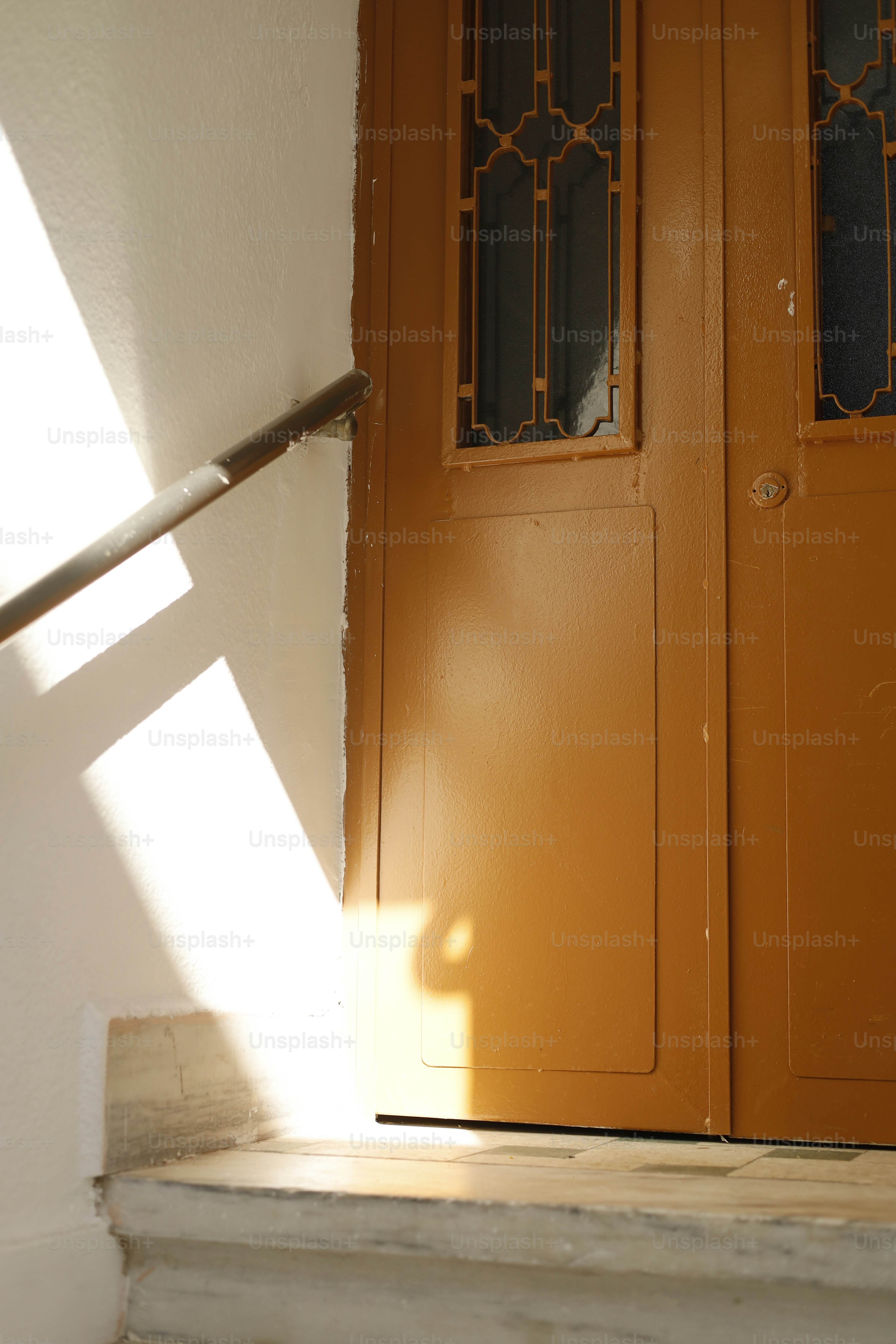 A luz do sol flui para uma porta com um corrimão.