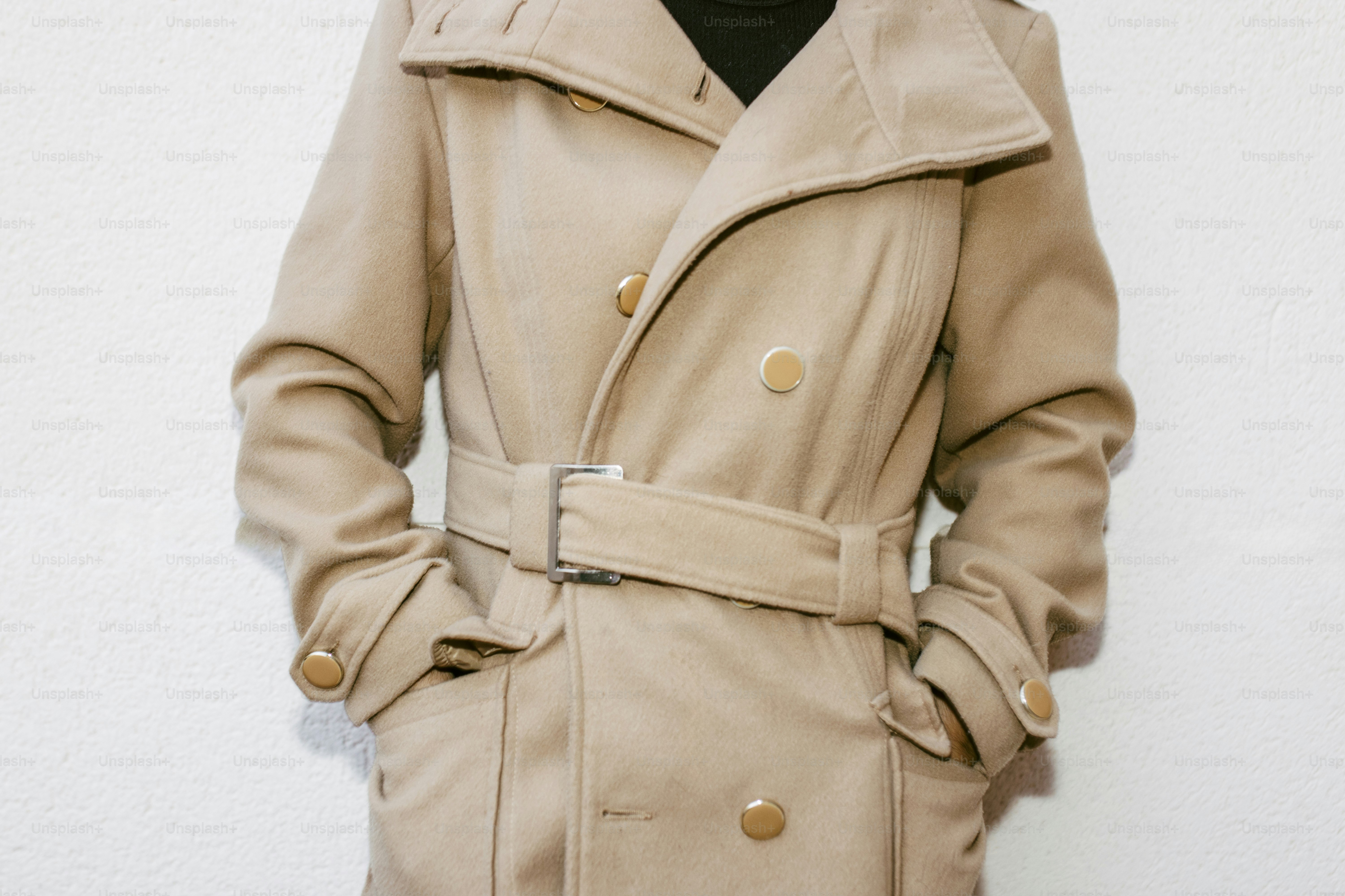 Person wearing a tan belted trench coat